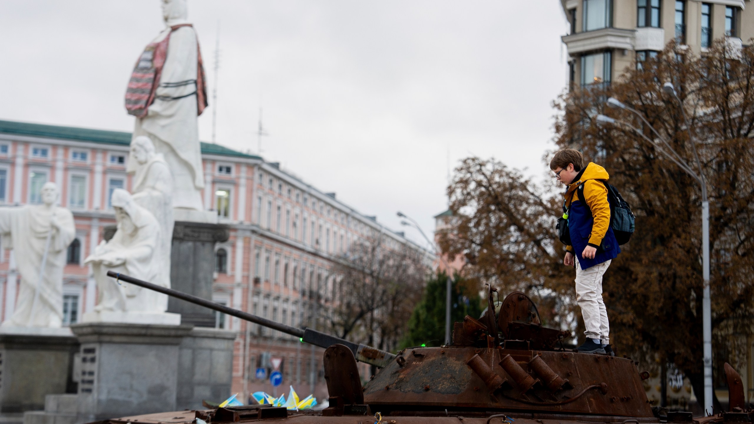 A boy stands on Russian burned APC in central Kyiv, Ukraine, Monday, Oct. 14, 2024. (AP Photo/Alex Babenko)