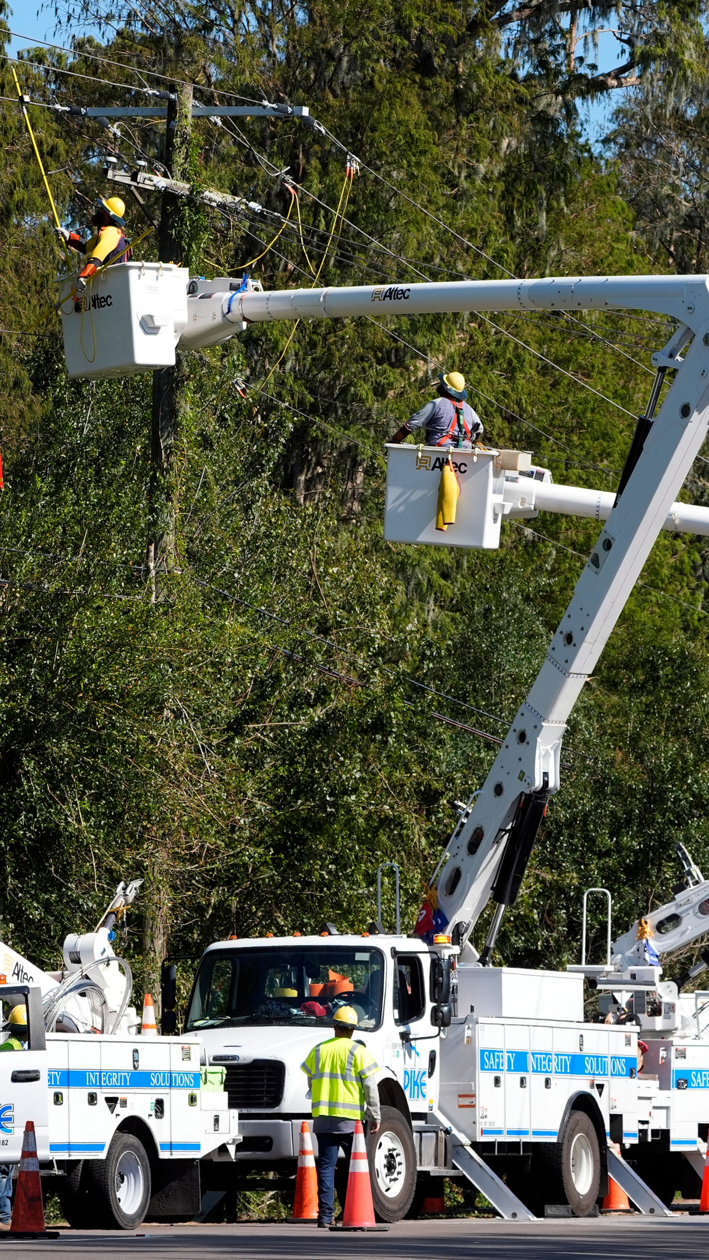 Pike Corporation linemen, of North Carolina, repair power lines damaged by Hurricane Milton Monday, Oct. 14, 2024, in Lithia, Fla. (AP Photo/Chris O'Meara)