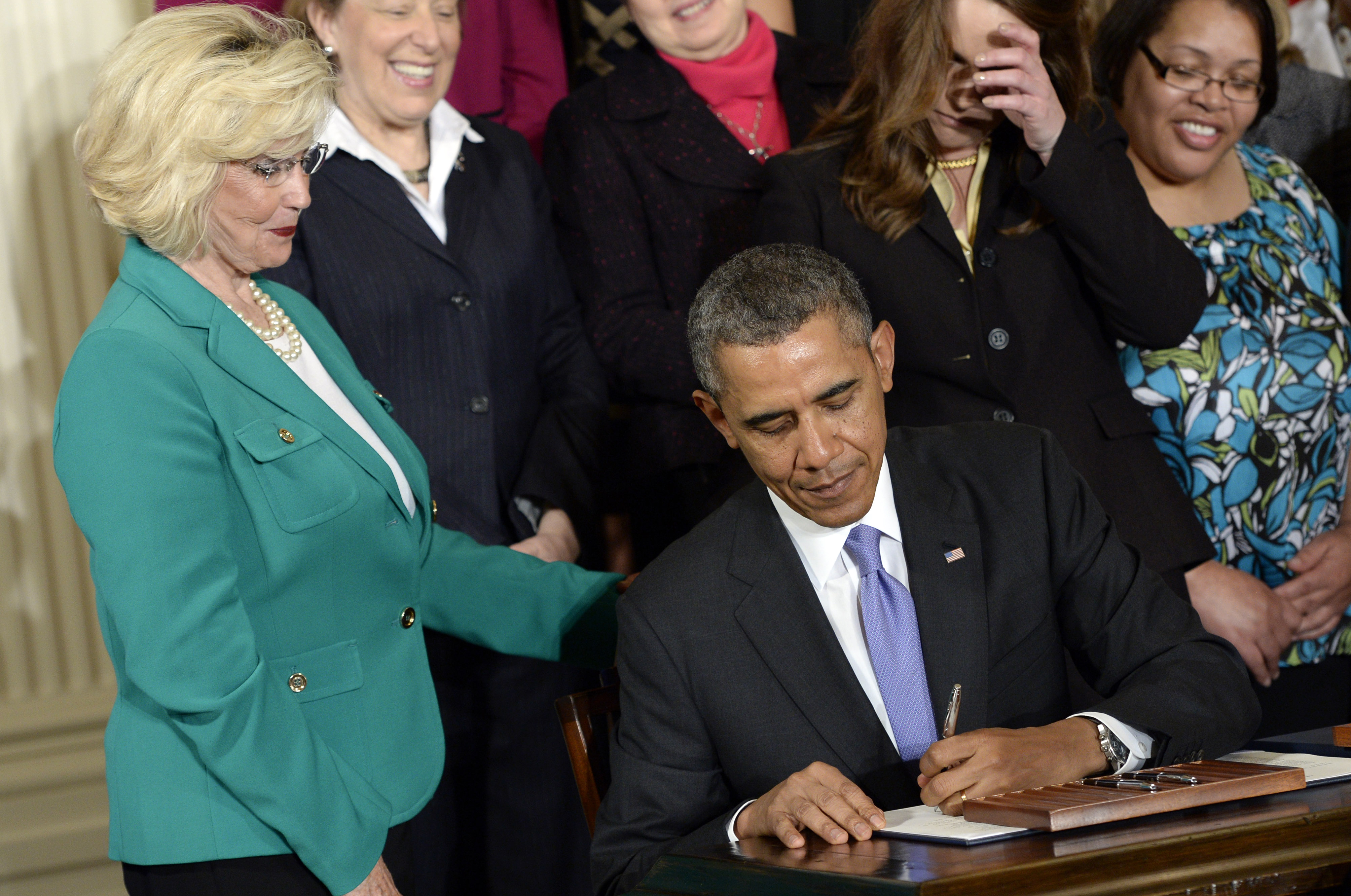 FILE - Lilly Ledbetter watches as President Barack Obama signs executive actions, with pending Senate legislation, aimed at closing a compensation gender gap that favors men, at the White House in Washington, April 8, 2014, during an event marking Equal Pay Day. (AP Photo/Susan Walsh, File)