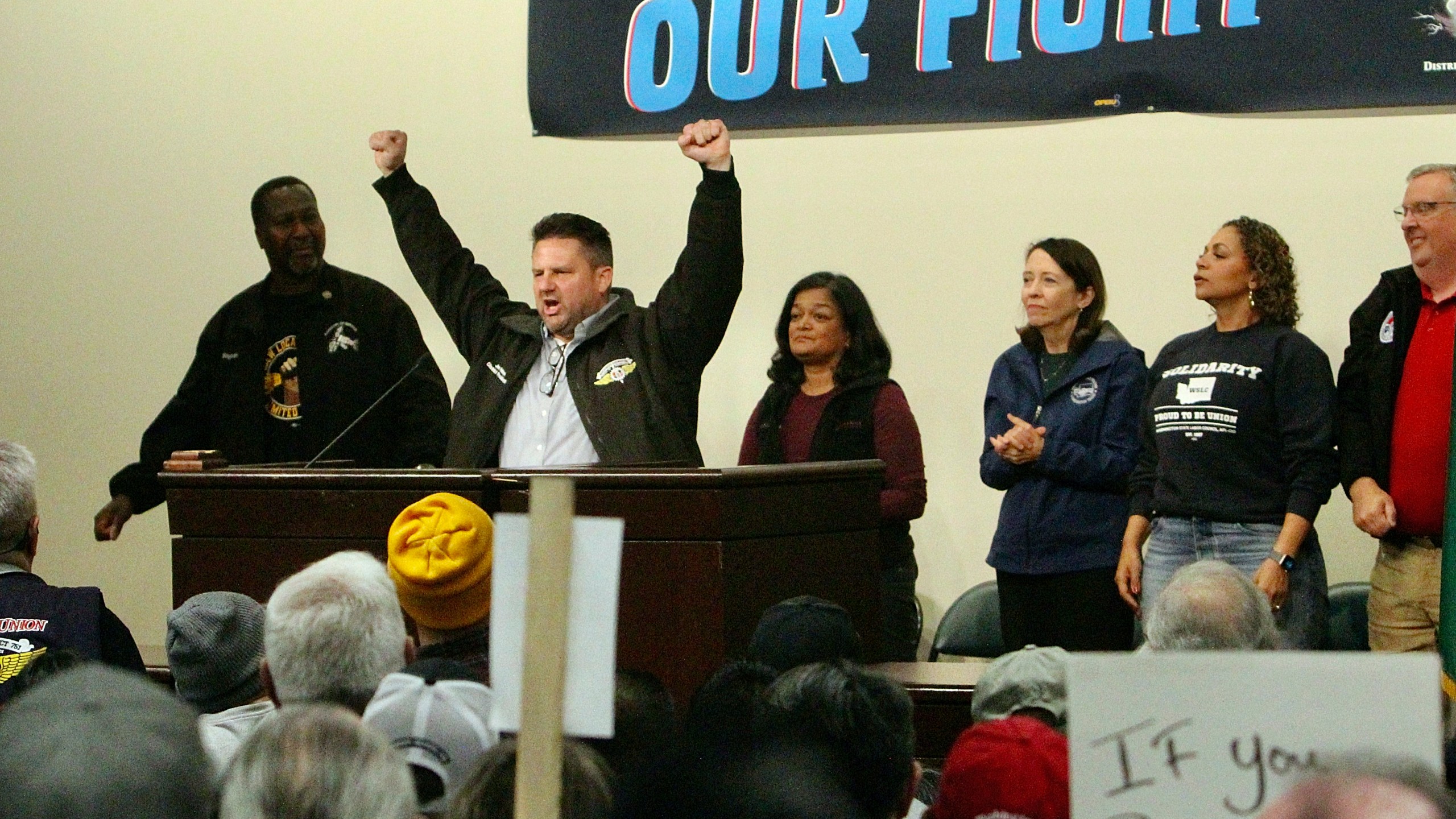 Jon Holden, IAM District 751 President, raises his arms as Sen. Maria Cantwell, D-Wash., Rep. Pramila Jayapal, D-Wash., and labor leaders stand behind him at a rally for Boeing union machinists, Tuesday, Oct. 15, 2024, in Seattle. (AP Photo/Manuel Valdes)