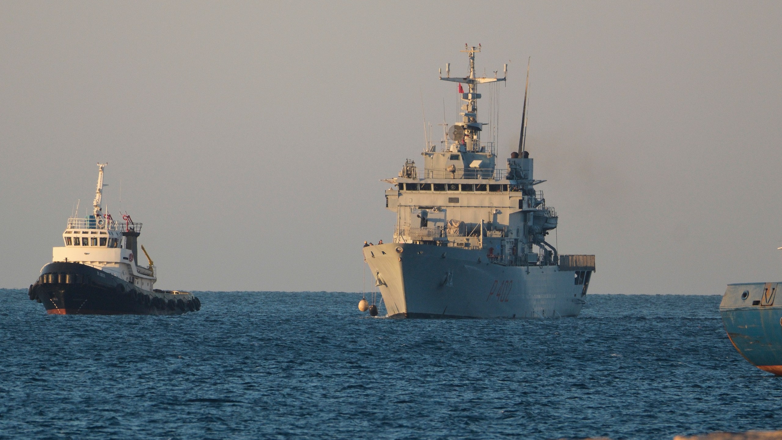 The Italian navy ship Libra, right, arrives at the port of Shengjin northwestern Albania Wednesday, Oct. 16, 2024, carrying the first group of migrants who were intercepted in international waters. (AP Photo/Vlasov Sulaj)