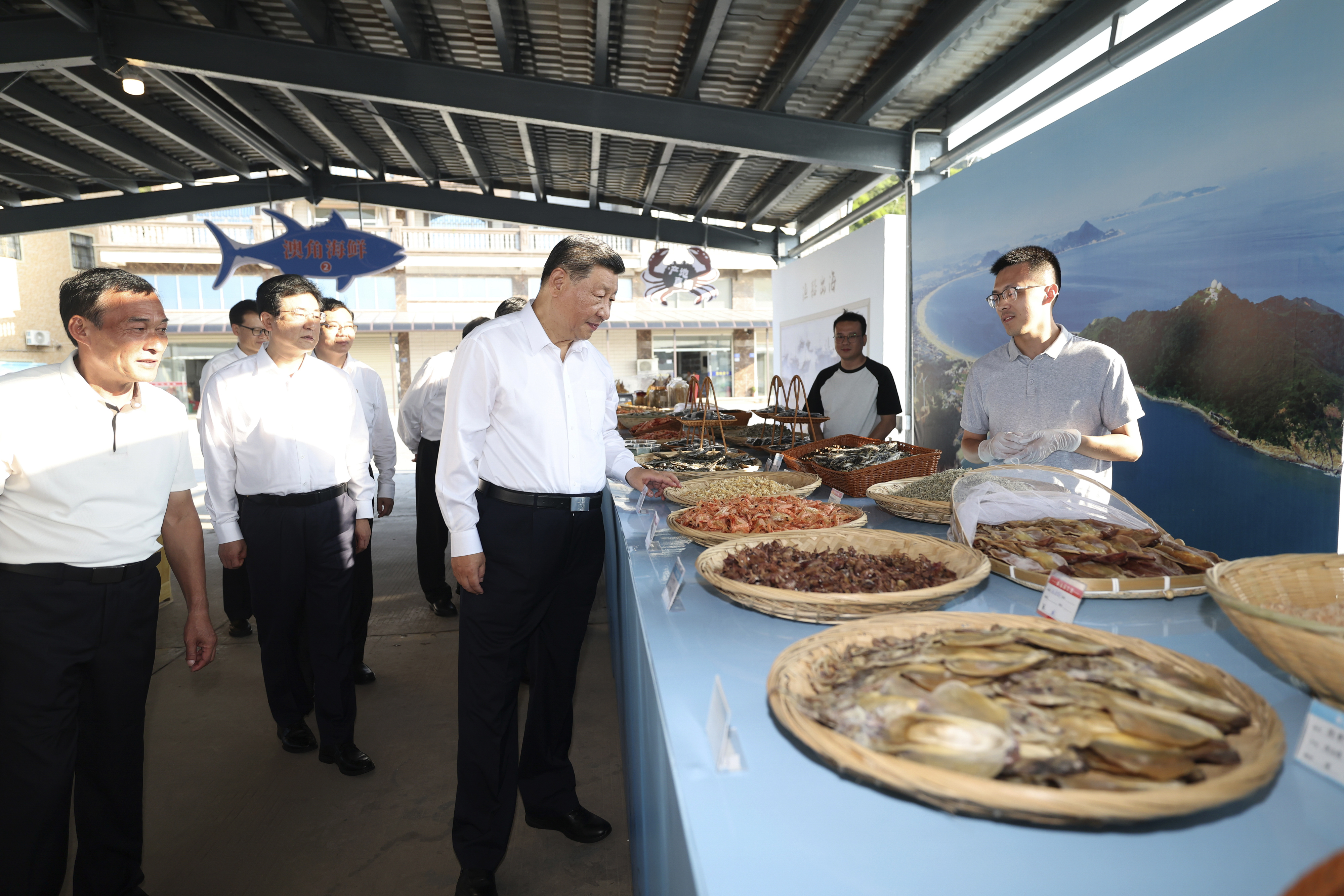 In this photo released by Xinhua News Agency, Chinese President Xi Jinping, center, learns about the sale of dried seafood and the fishing harvest at Aojiao Village of Dongshan County in the city of Zhangzhou during an inspection tour in southeastern China's Fujian province on Tuesday, Oct. 15, 2024. (Ju Peng/Xinhua via AP)