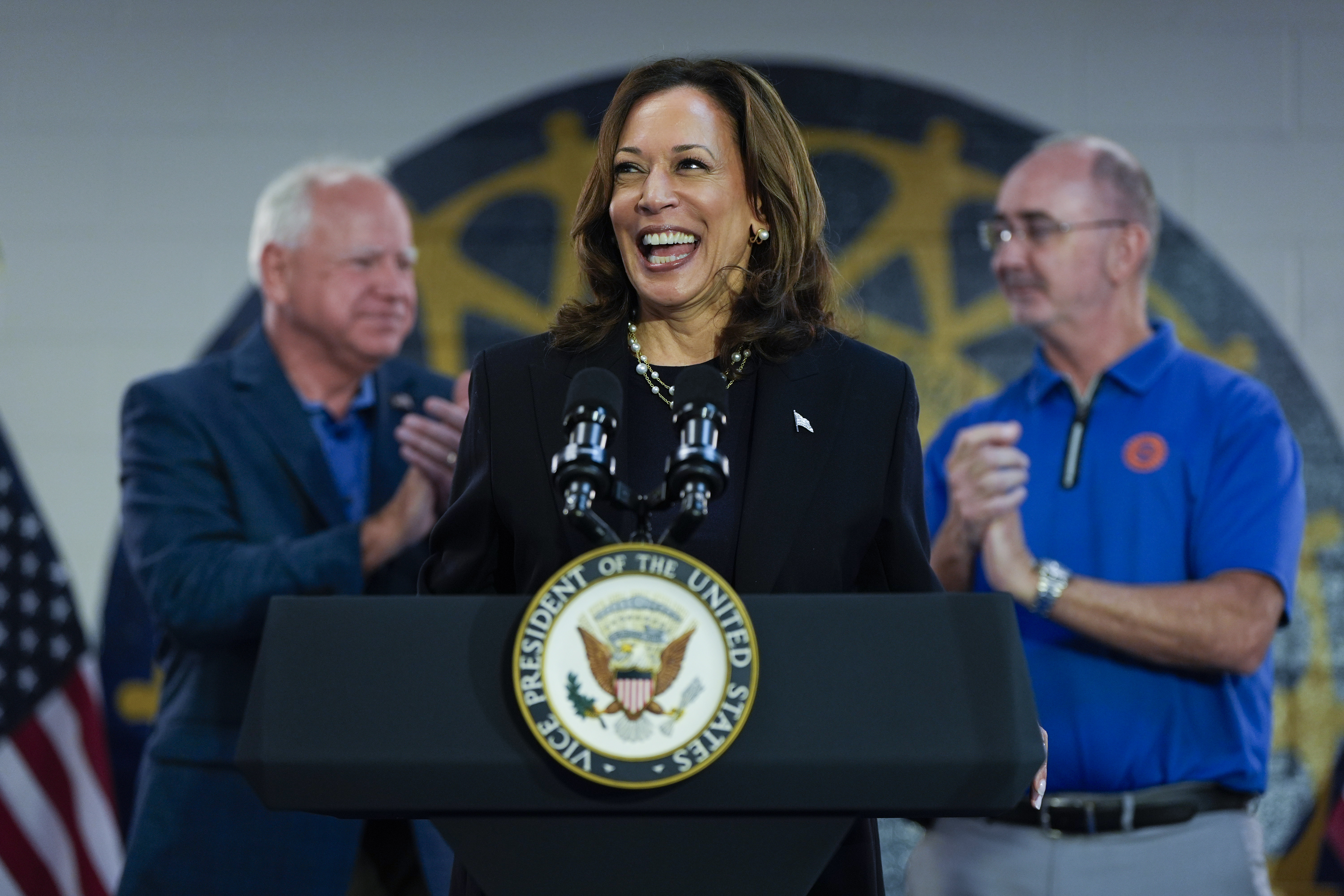 FILE - Democratic presidential nominee Vice President Kamala Harris, with Democratic vice presidential nominee Minnesota Gov. Tim Walz, left, and UAW President Shawn Fain, speaks at a campaign rally at UAW Local 900, Aug. 8, 2024, in Wayne, Mich. (AP Photo/Julia Nikhinson, File)