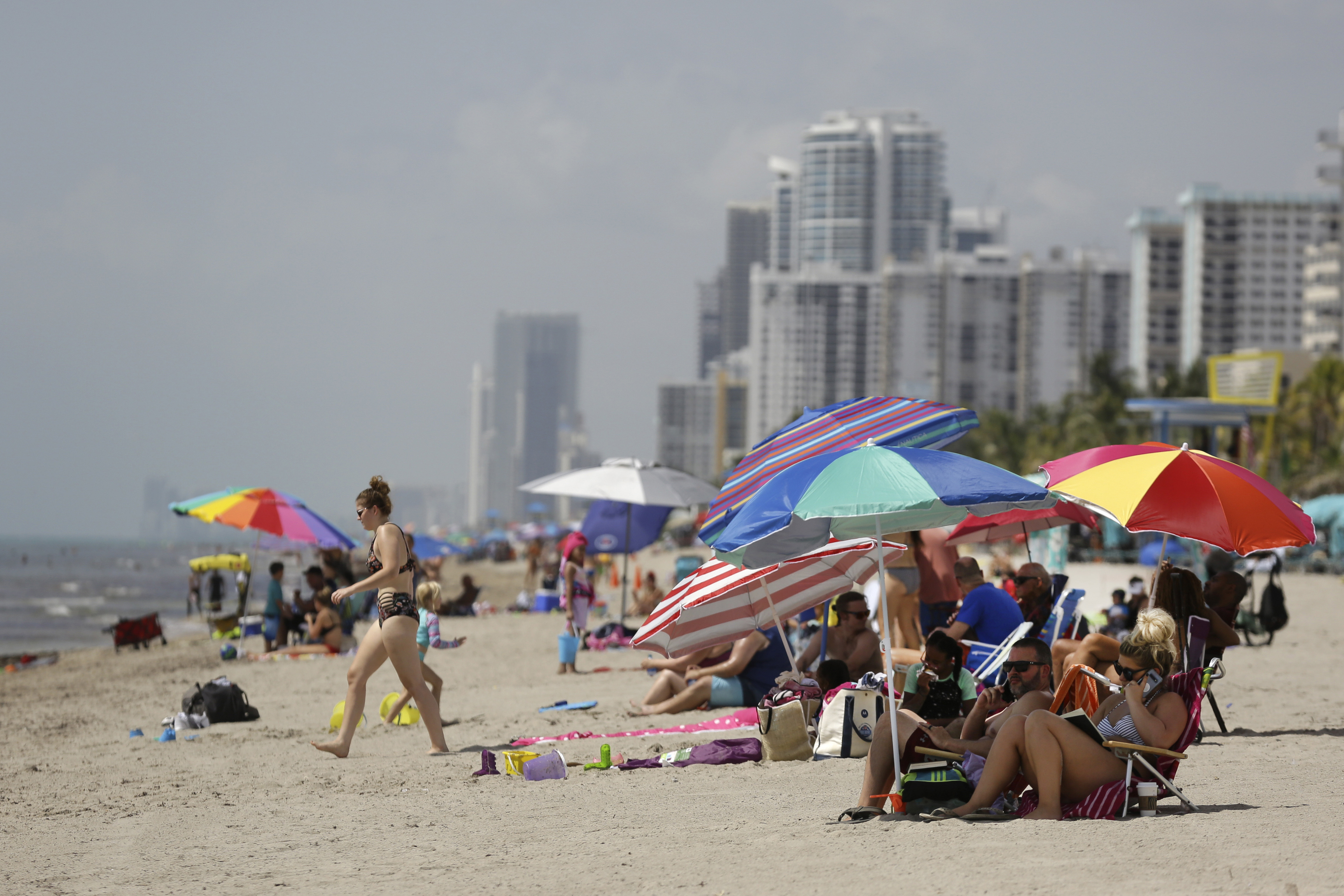 FILE - People sit on Hollywood Beach on July 2, 2020, in Hollywood, Fla. (AP Photo/Lynne Sladky, File)