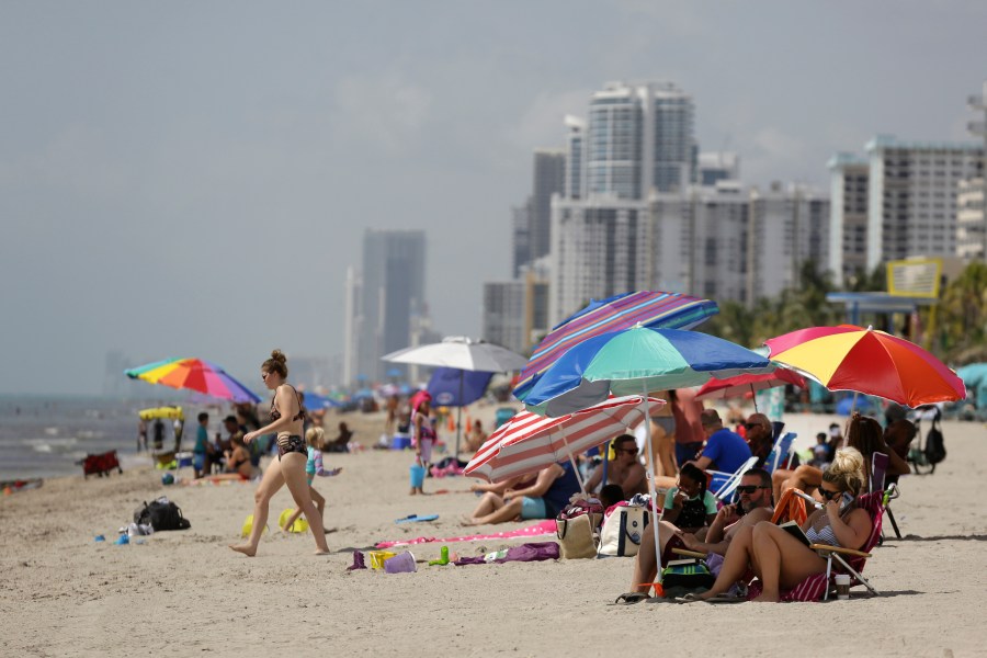 FILE - People sit on Hollywood Beach on July 2, 2020, in Hollywood, Fla. (AP Photo/Lynne Sladky, File)