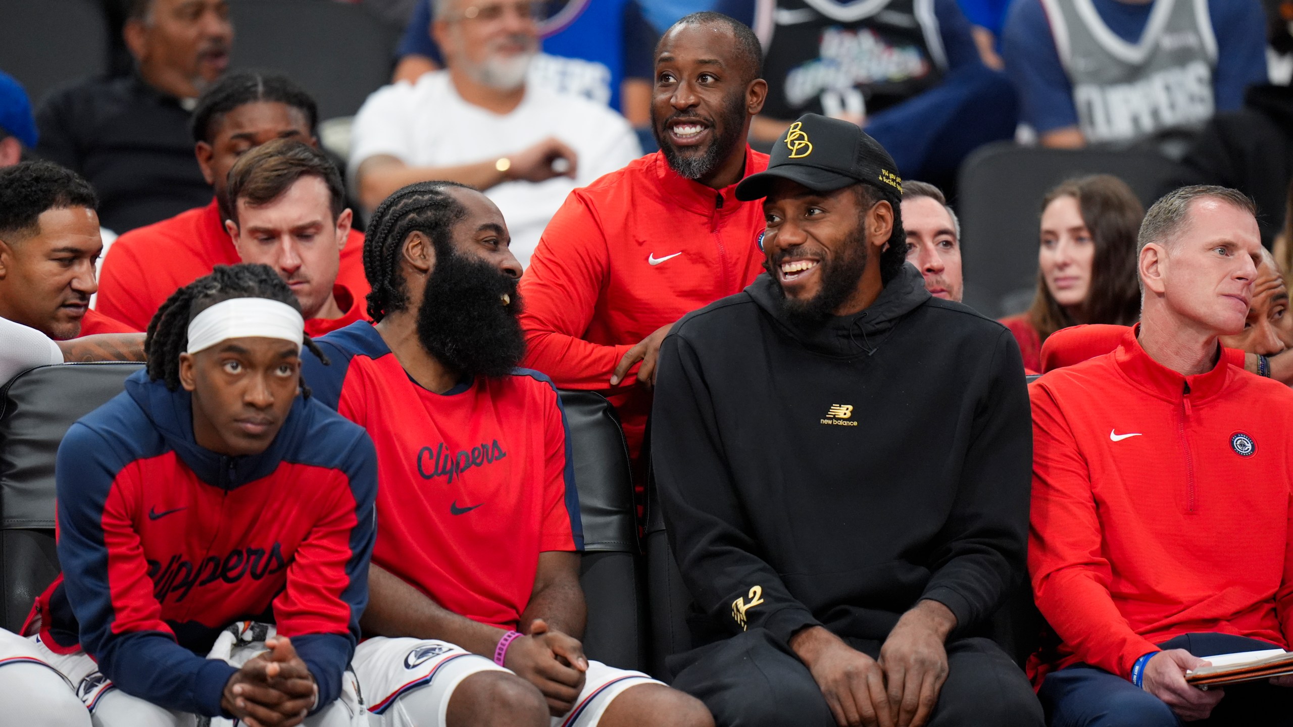 Los Angeles Clippers' James Harden, center left, shares a light moment with Kawhi Leonard during the second half of an NBA preseason basketball game against the Dallas Mavericks Monday, Oct. 14, 2024, in Inglewood, Calif. (AP Photo/Jae C. Hong)