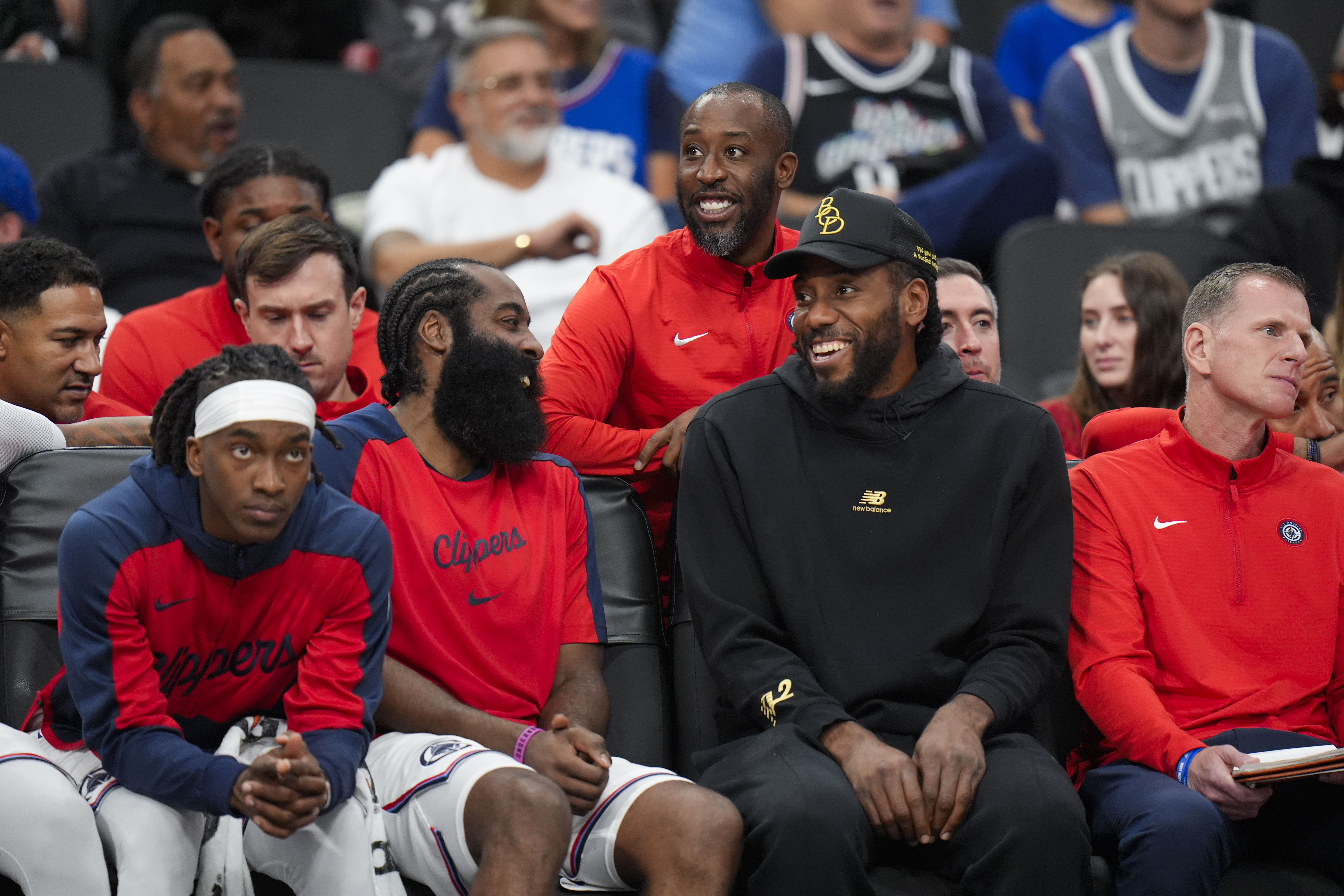 Los Angeles Clippers' James Harden, center left, shares a light moment with Kawhi Leonard during the second half of an NBA preseason basketball game against the Dallas Mavericks Monday, Oct. 14, 2024, in Inglewood, Calif. (AP Photo/Jae C. Hong)