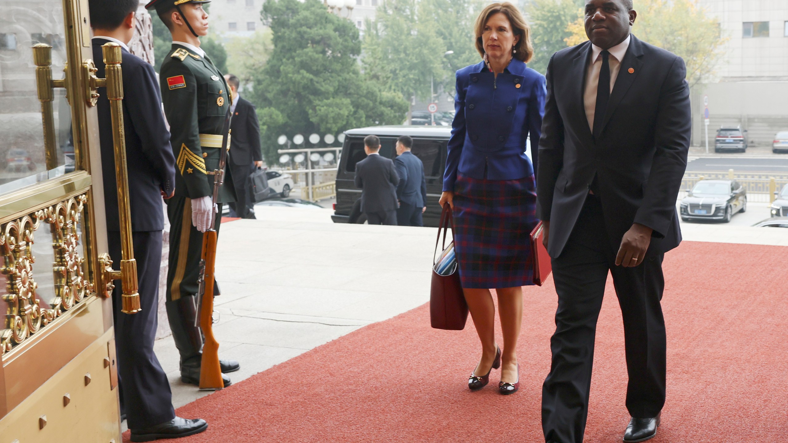 Britain's Foreign Secretary David Lammy, right, and British Ambassador to China Caroline Wilson arrive to the Great Hall of the People in Beijing Friday, Oct. 18, 2024. (Florence Lo/Pool Photo via AP)