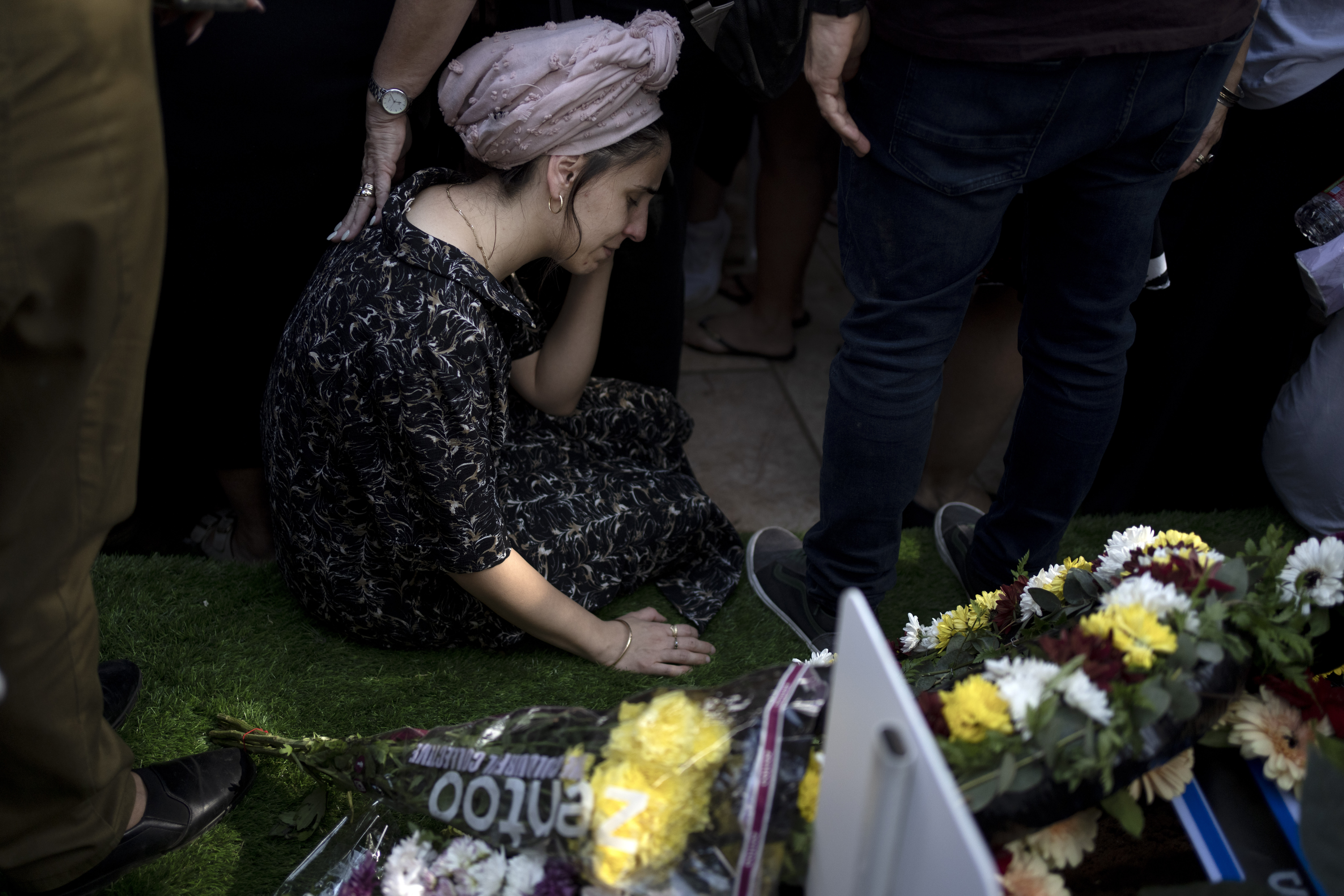 A relative weeps at the grave of Israel Defense Forces Captain Elad Siman Tov, who was killed in action in Lebanon, during his funeral in Petah Tikva, Israel, Friday, Oct. 18, 2024. (AP Photo/Maya Alleruzzo)