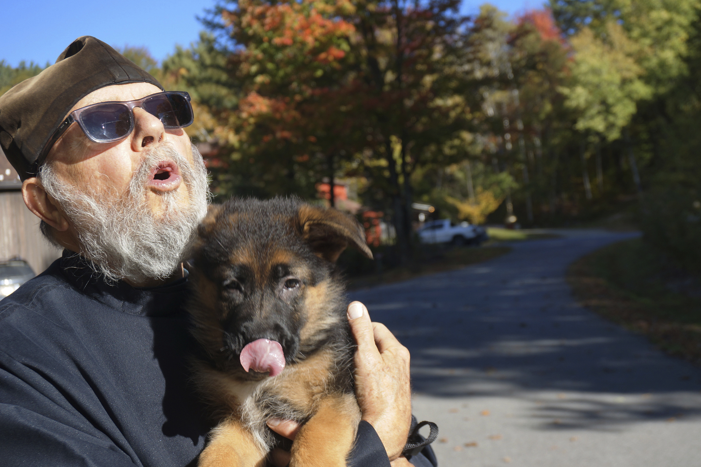 Brother Luke, an Orthodox Christian monk, holds his 10-week-old German shepherd Pyrena on the grounds of the New Skete monastery, where he directs the dog breeding program that has provided both financial and spiritual support to the community for decades outside Cambridge, N.Y., on Oct. 12, 2024. (AP Photo/Giovanna Dell’Orto)