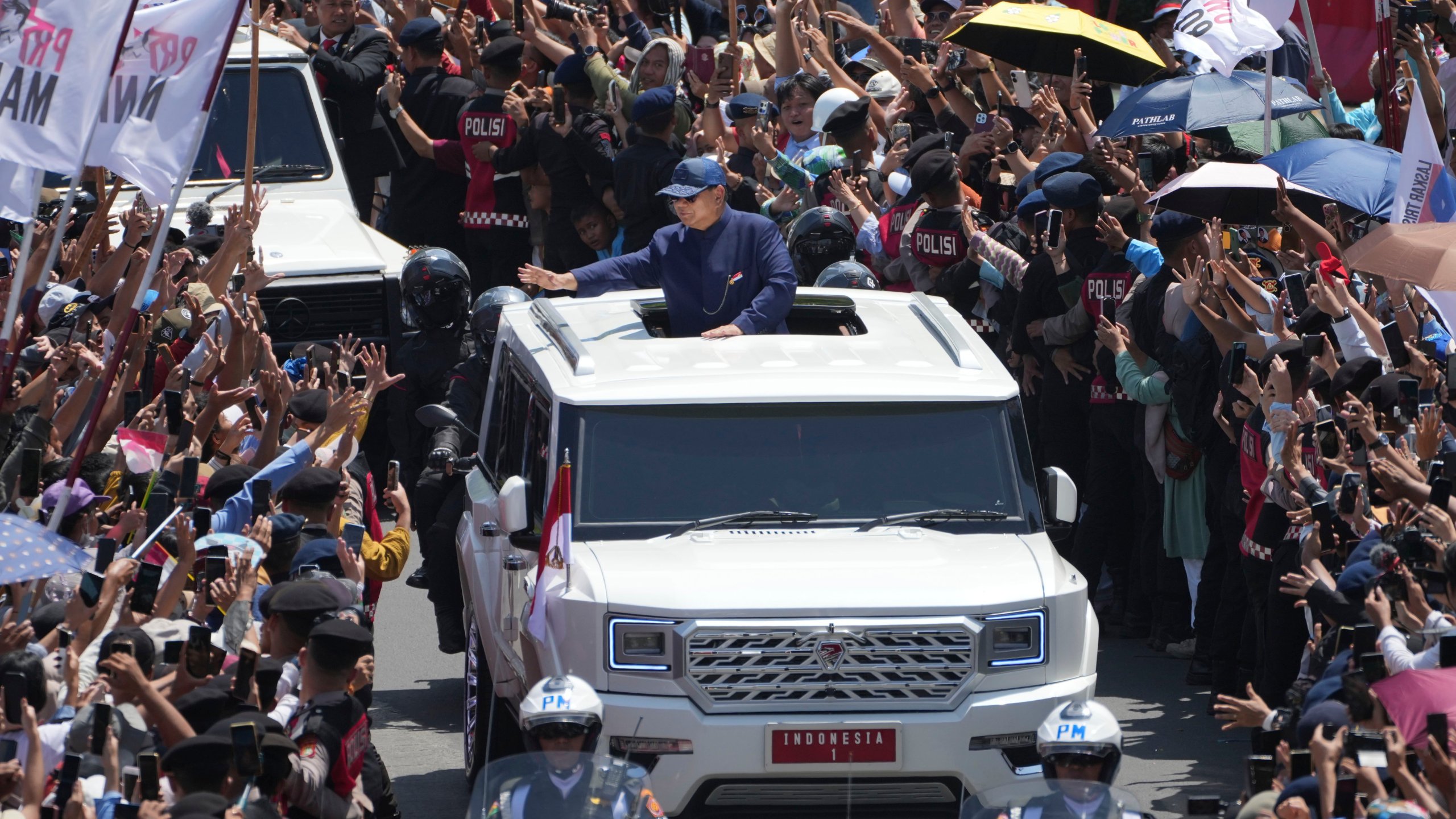 Newly-inaugurated Indonesian President Prabowo Subianto, center, greets supporters after being sworn in as the country's eighth president in Jakarta, Indonesia, Sunday, Oct. 20, 2024. (AP Photo/Dita Alangkara)