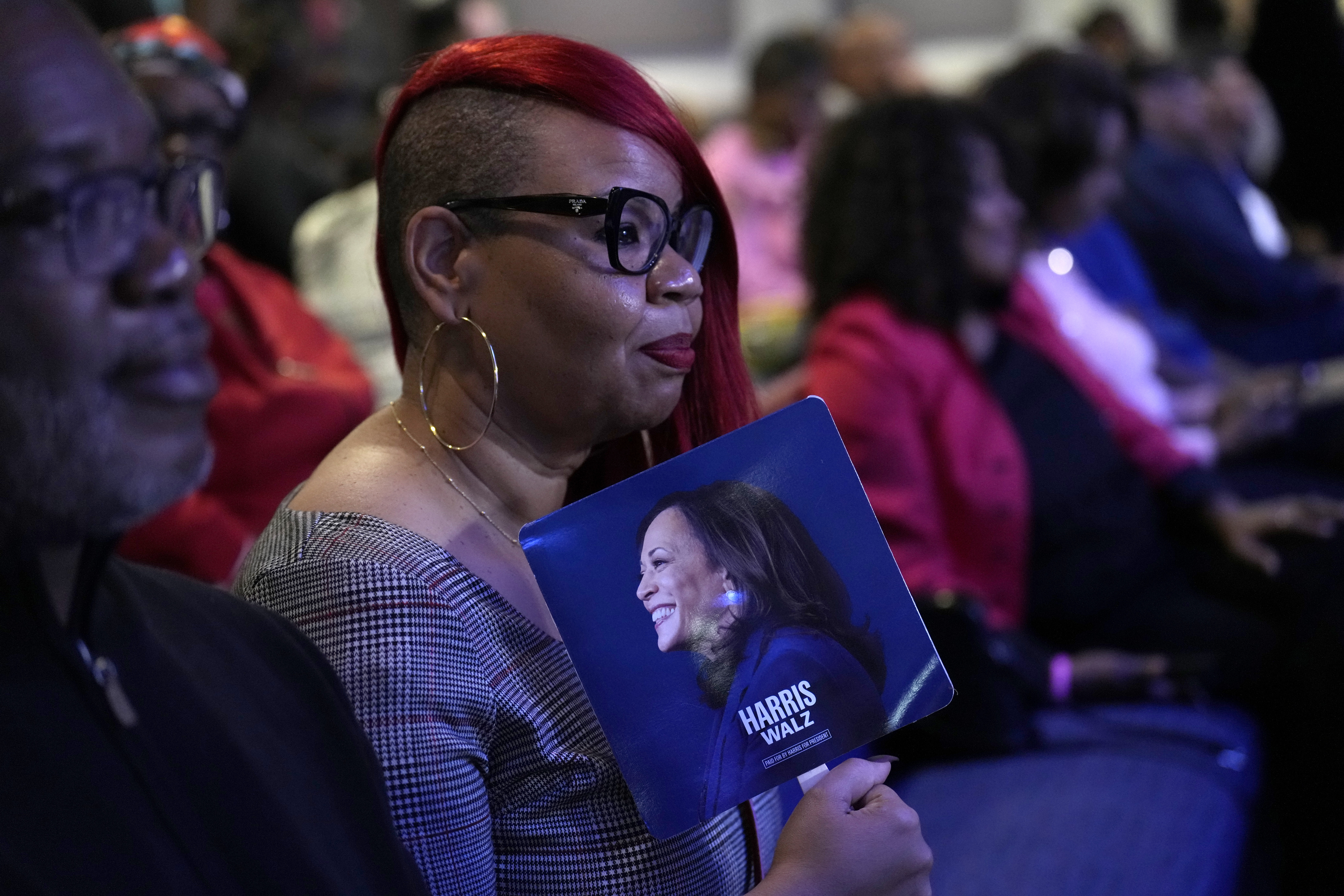 An attendee holds a campaign fan before Democratic presidential nominee Vice President Kamala Harris arrives to speak during a church service and early vote event at Divine Faith Ministries International, Sunday, Oct. 20, 2024, in Jonesboro, Ga. (AP Photo/Jacquelyn Martin)