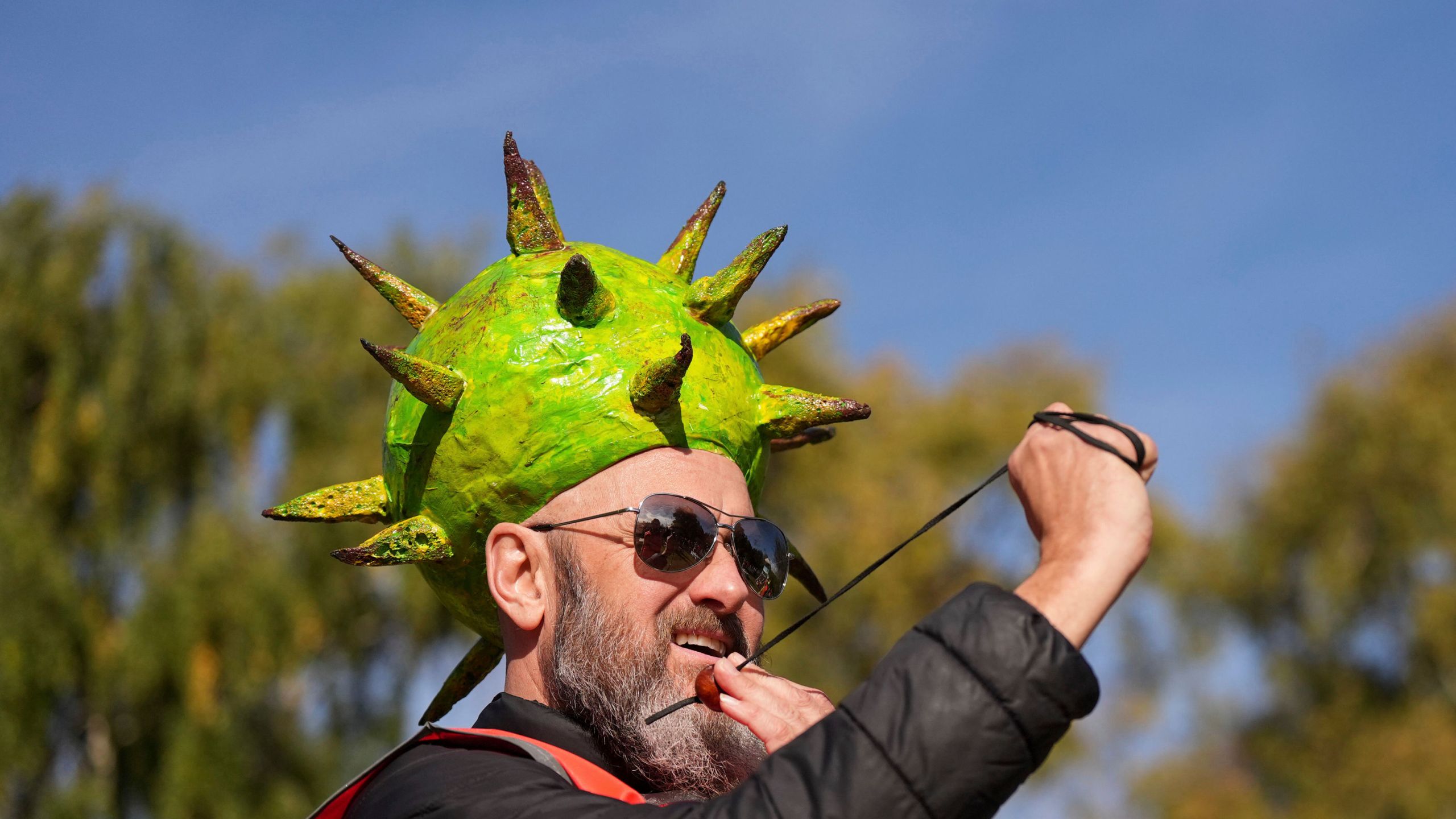 Competitor Neil Morbey wearing a conker themed hat takes part in the annual World Conker Championships at the Shuckburgh Arms in Southwick, Peterborough, England, Sunday Oct. 13, 2024. (Jacob King/PA via AP)