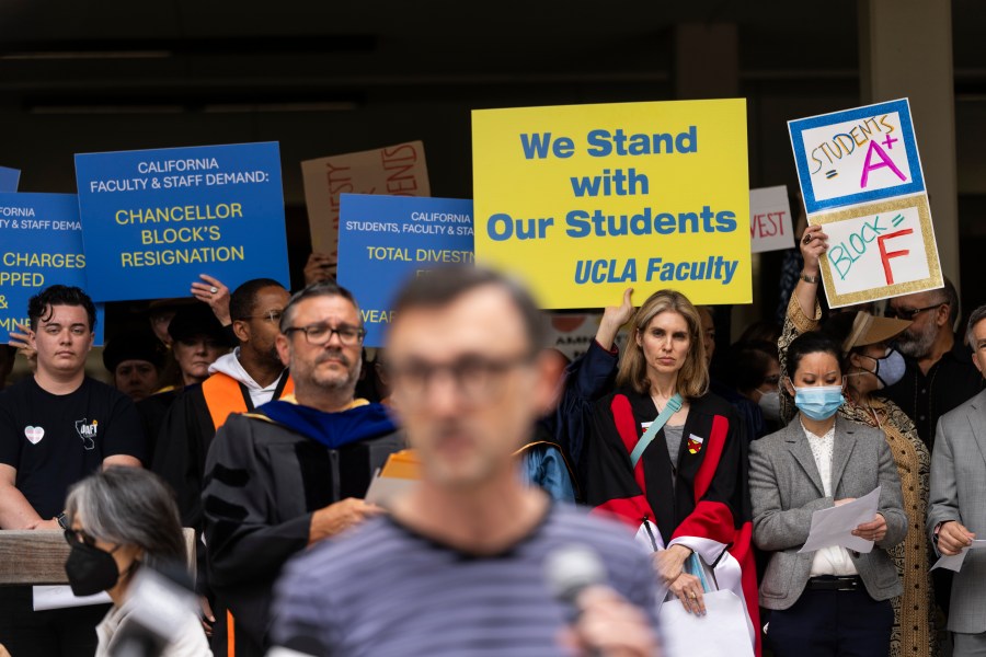 FILE - UCLA faculty and staff members hold up signs during a news conference at UCLA in Los Angeles, Thursday, May 9, 2024. (AP Photo/Jae C. Hong, File)