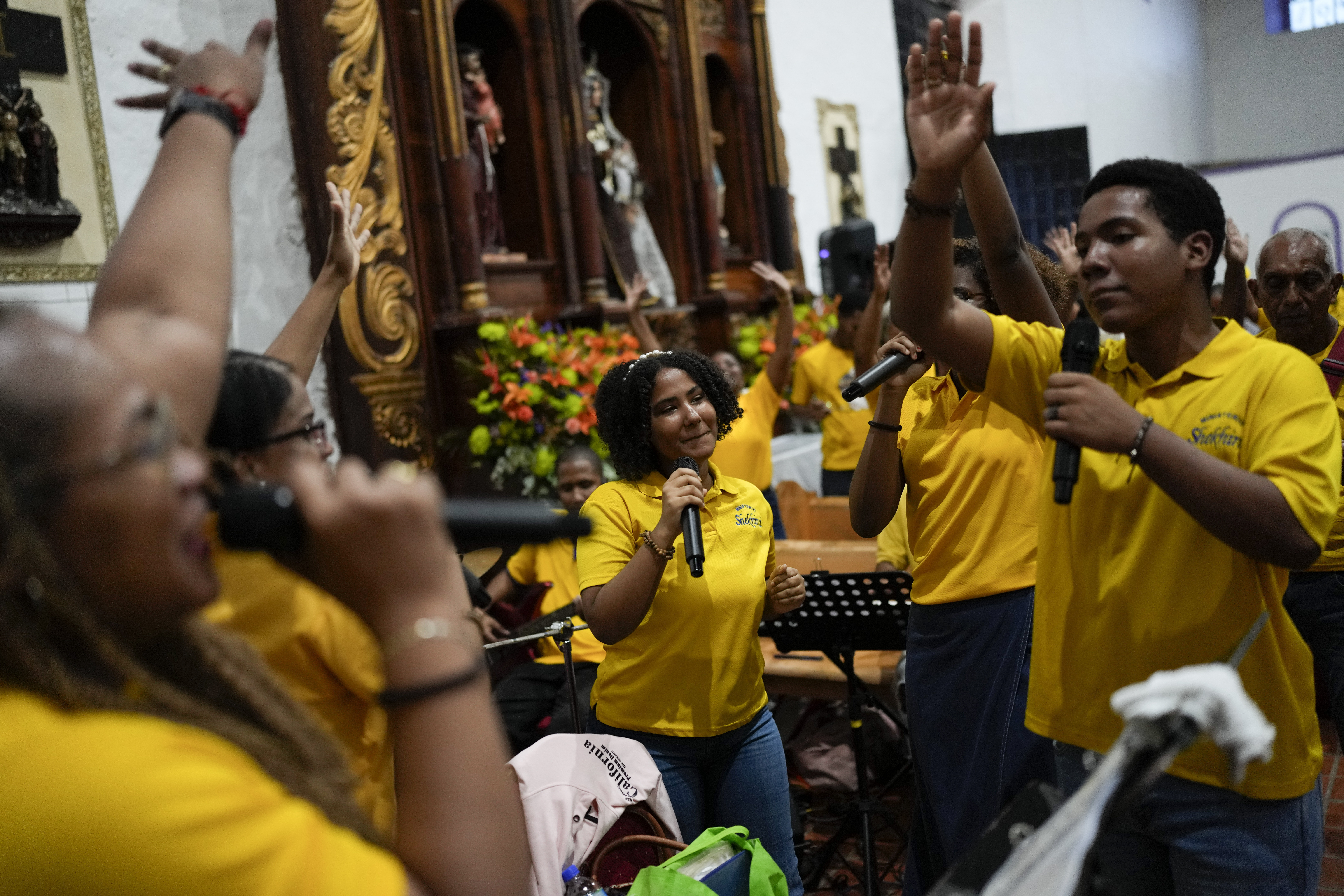 Pilgrims sing and dance inside San Felipe Church to honor the Black Christ in Portobelo, Panama, Monday, Oct. 21, 2024, during a festival celebrating the iconic statue that was found on the shore in 1658. (AP Photo/Matias Delacroix)