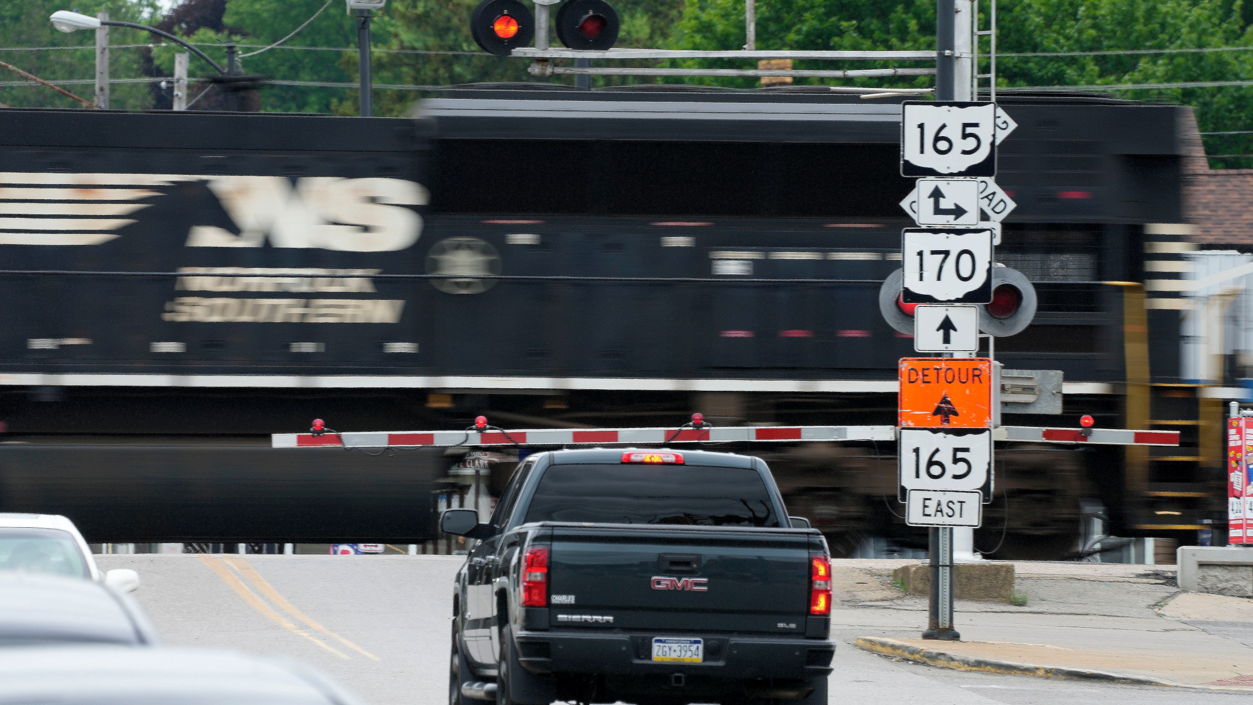 FILE - Traffic backs up as a Norfolk Southern freight train rolls through a crossing in downtown East Palestine, Ohio, on June 22, 2023. (AP Photo/Gene J. Puskar, File)