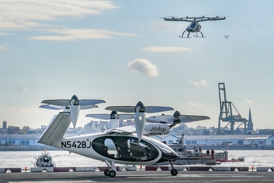 FILE - An electric vertical takeoff and landing (eVTOL) aircraft, flies above the Joby eVTOL aircraft, during a demonstration of eVTOLs Nov. 13, 2023, in New York. (AP Photo/Bebeto Matthews, File)