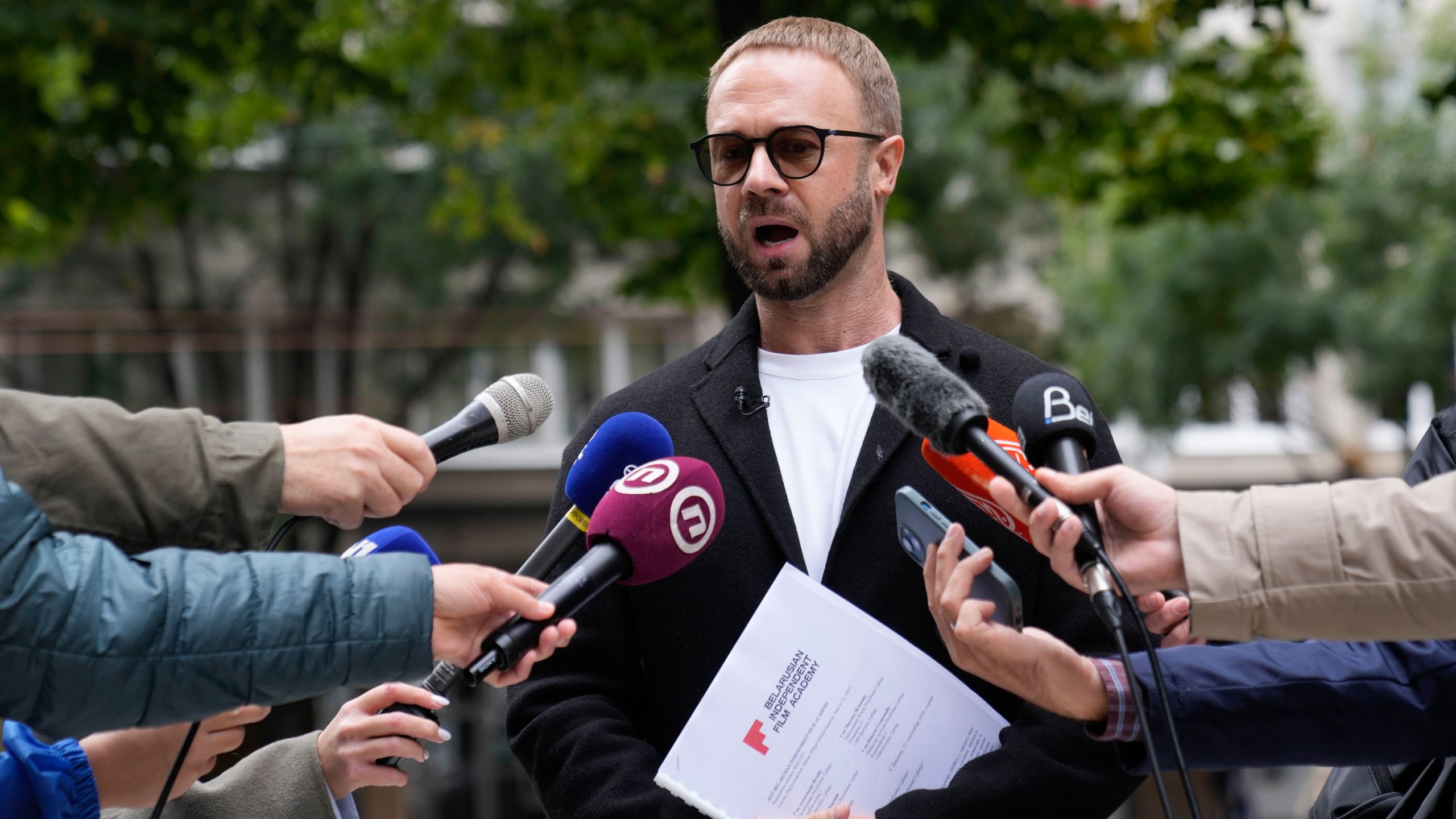 FILE - Prominent critic of the Belarusian government in Minsk, Andrei Hniot, speaks to media in front of the presidency building in Belgrade, Serbia, Monday, Sept. 16, 2024. (AP Photo/Darko Vojinovic, File)