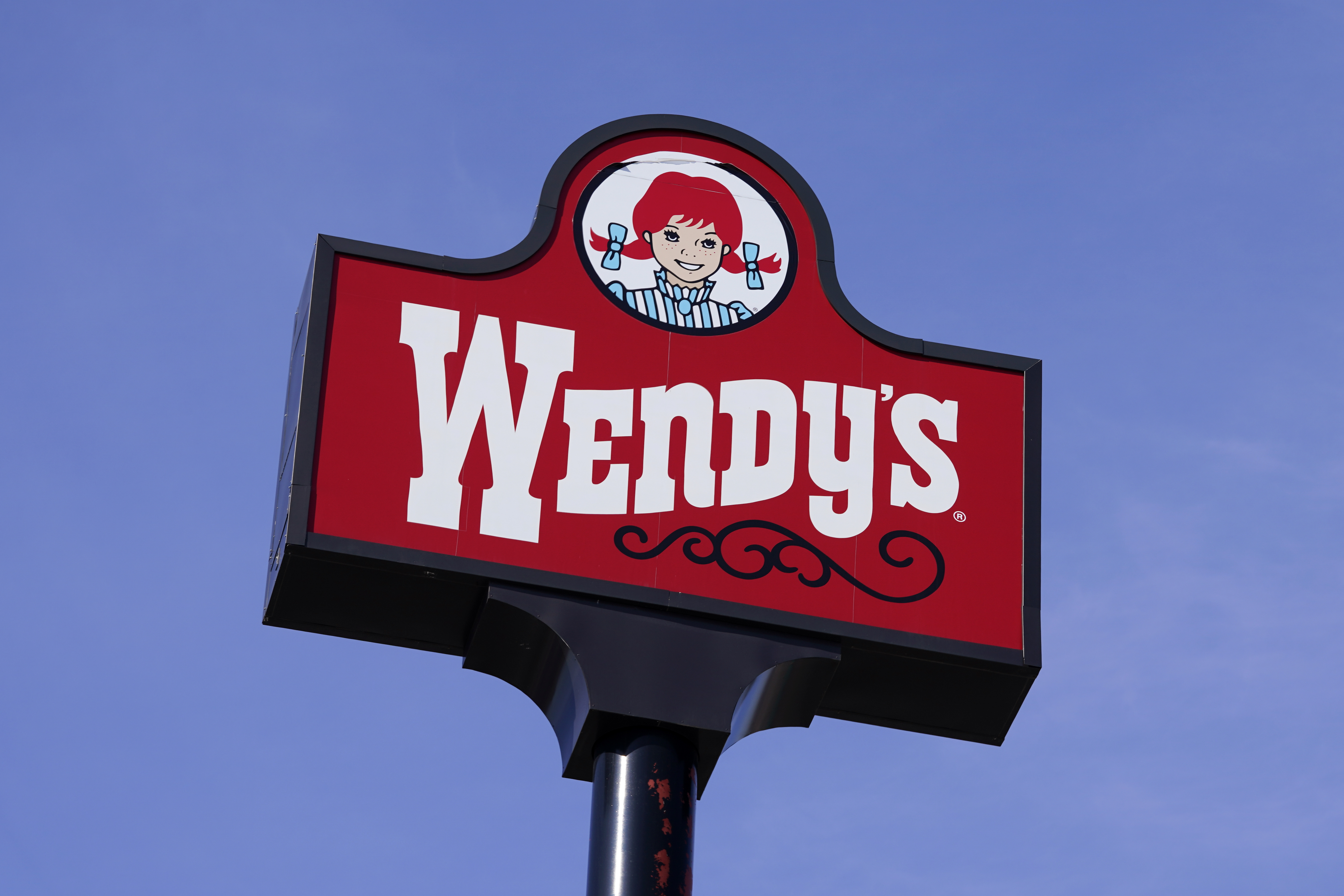 FILE - A sign for Wendy's restaurant stands over one of its locations, Feb. 25, 2021, in Des Moines, Iowa. (AP Photo/Charlie Neibergall, File)