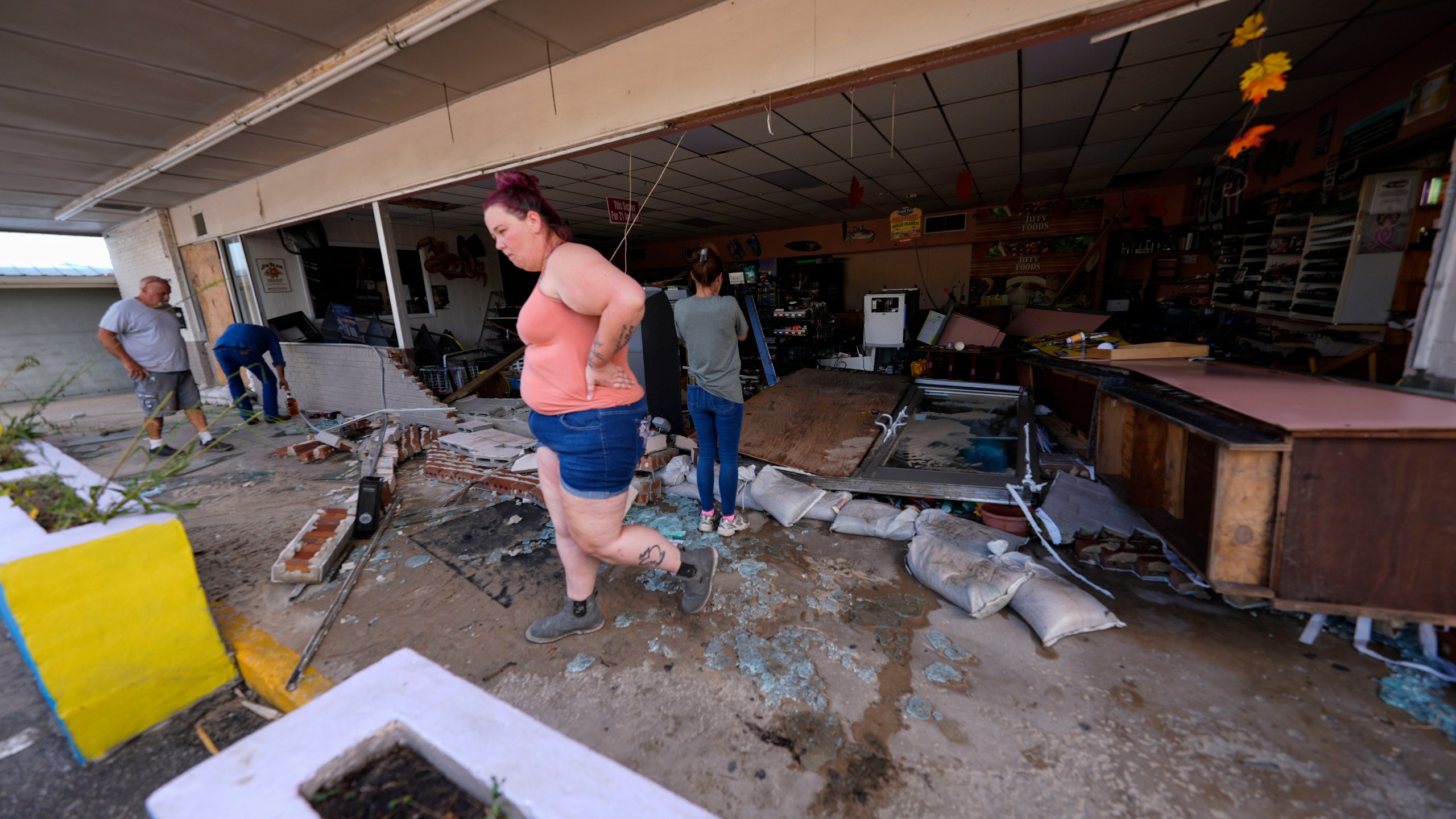 FILE - Kegan Ward, assistant manager of Swami Spirits, walks through debris of the damaged store in the aftermath of Hurricane Helene, in Cedar Key, Fla., on Sept. 27, 2024. (AP Photo/Gerald Herbert, File)