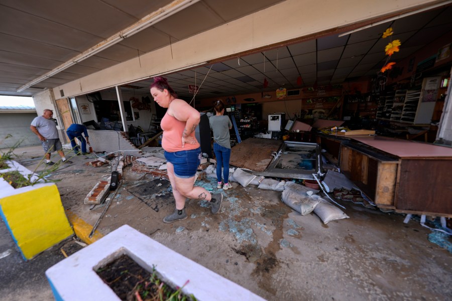 FILE - Kegan Ward, assistant manager of Swami Spirits, walks through debris of the damaged store in the aftermath of Hurricane Helene, in Cedar Key, Fla., on Sept. 27, 2024. (AP Photo/Gerald Herbert, File)