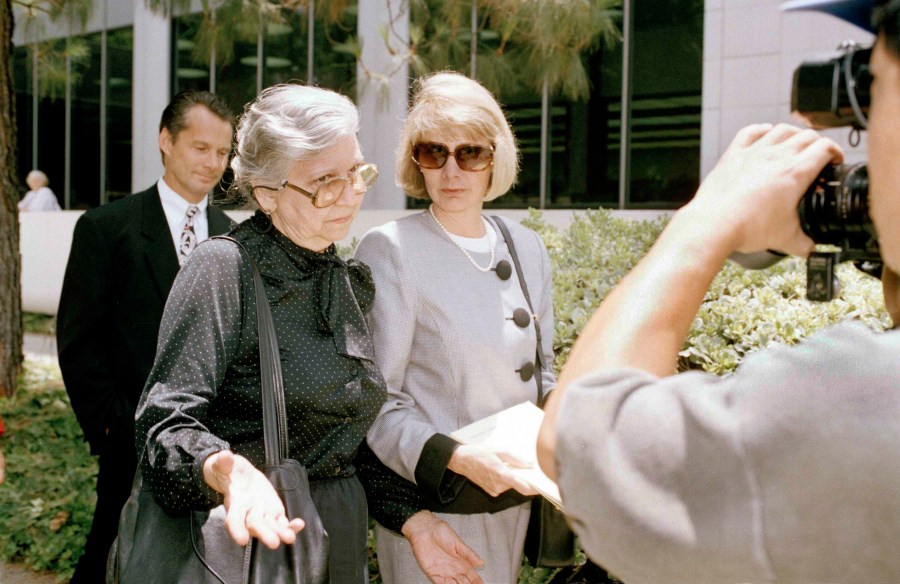 FILE - Maria Menendez, grandmother of two Beverly Hills brothers charged with murdering their millionaire parents, left, encounters news cameras as Jill Lansing, one of the defense attorneys in the case, looks on, outside the Van Nuys courthouse in Los Angeles, June 14, 1993. (AP Photo/Mark J. Terrill., File)