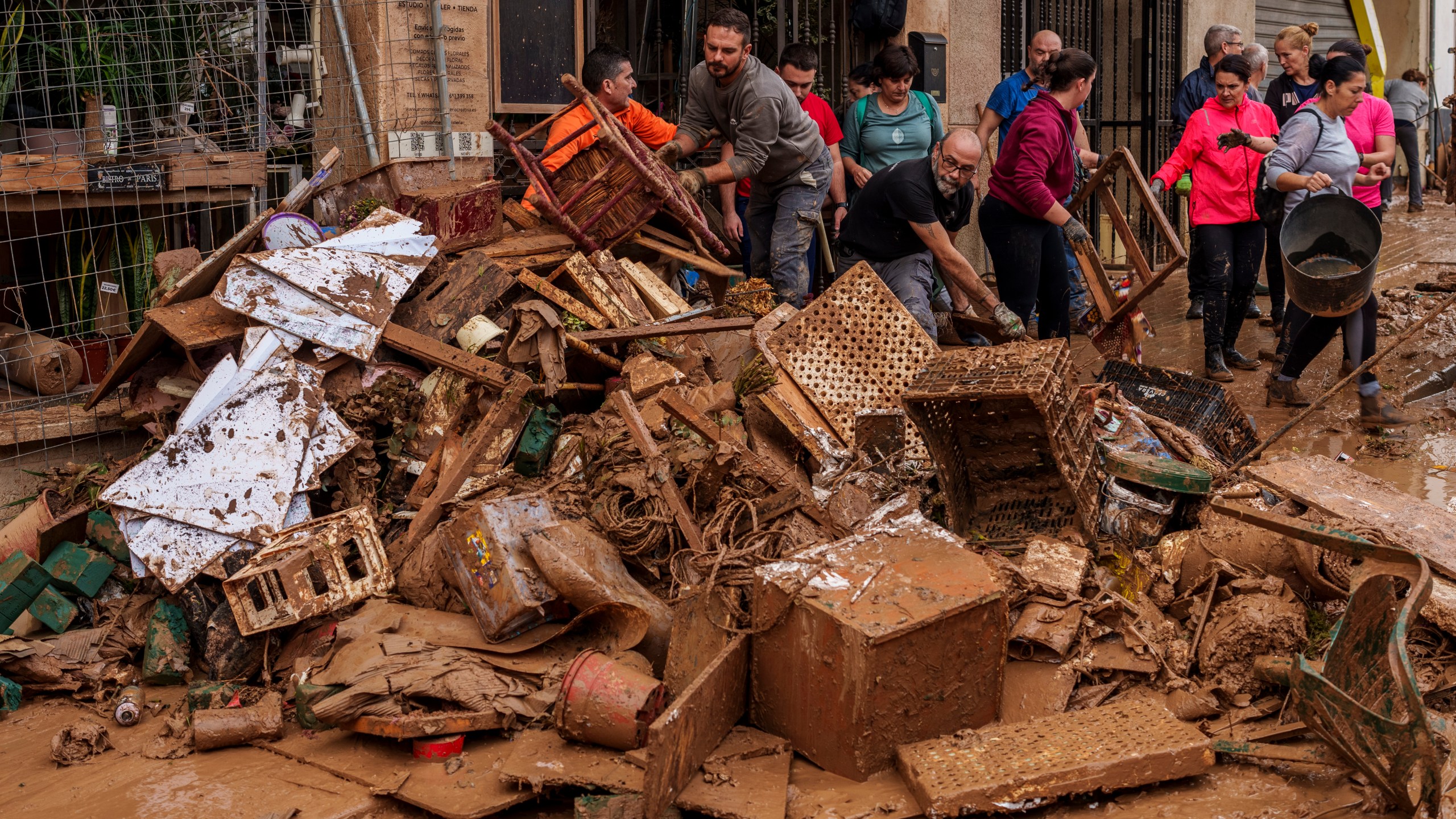 People clean mud from a shop affected by floods in Chiva, Spain, Friday, Nov. 1, 2024. (AP Photo/Manu Fernandez)