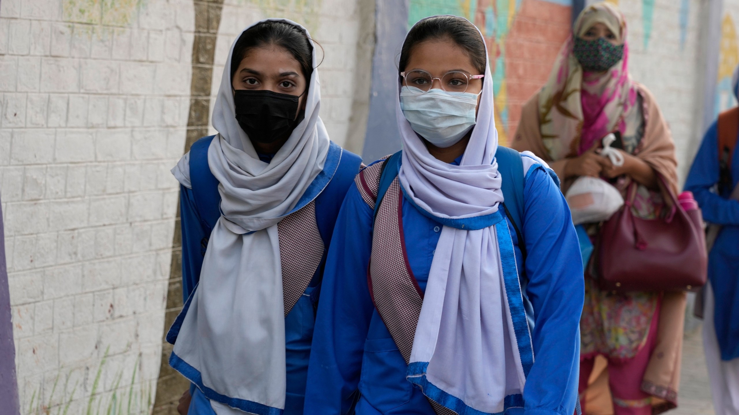 Students wear mask to protect themselves from poor air quality due to increasing smog in the city as they head to their school, in Lahore, Pakistan, Monday, Nov. 4, 2024. (AP Photo/K.M. Chaudary)