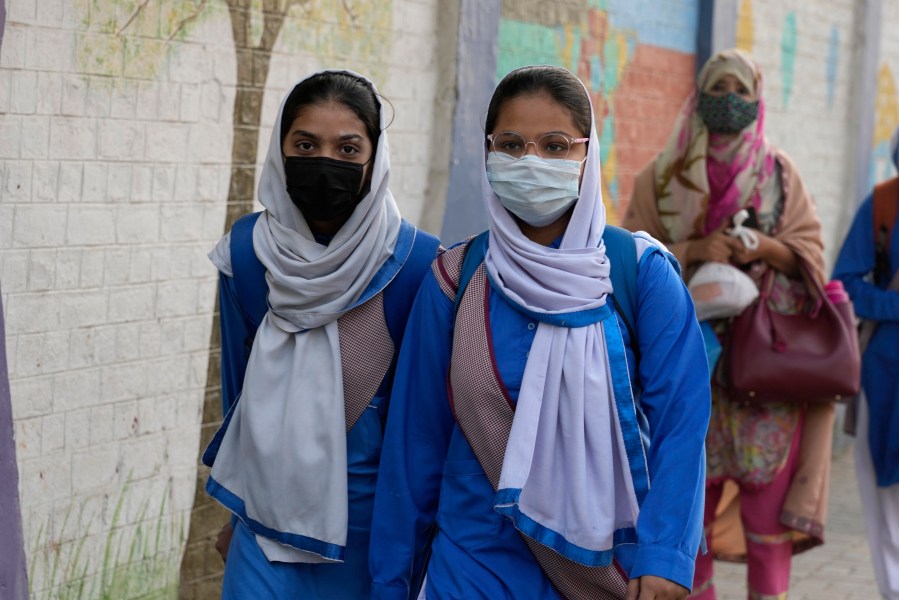 Students wear mask to protect themselves from poor air quality due to increasing smog in the city as they head to their school, in Lahore, Pakistan, Monday, Nov. 4, 2024. (AP Photo/K.M. Chaudary)