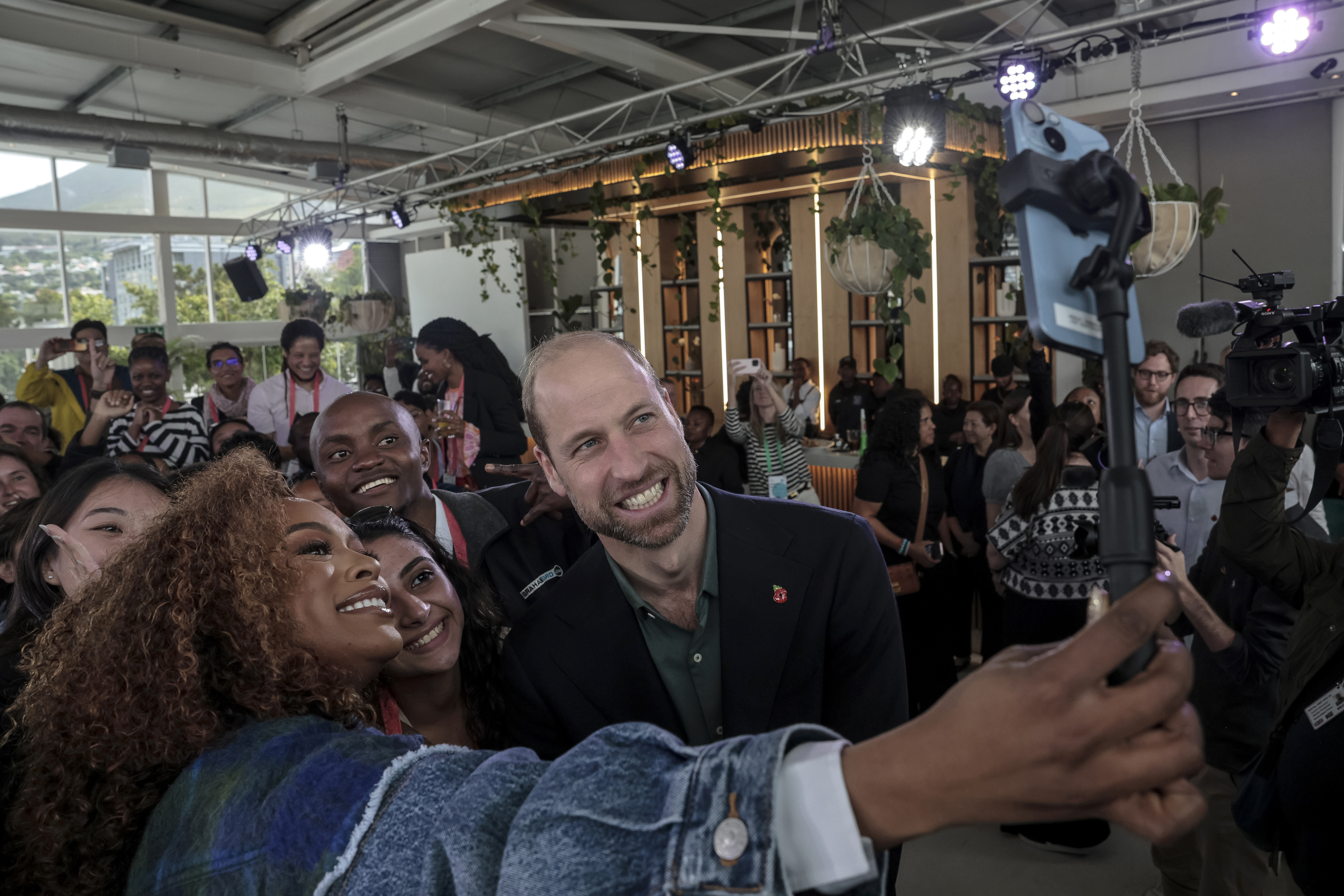 Nomzamo Mbatha, left, the host of Earthshot Week, takes a selfie with Britain's Prince William and a group of young people at the Earthshot Prize Climate Leaders Youth Programme at Rooftop on Bree in Cape Town, South Africa, Monday Nov. 4, 2024. (Gianluigi Guercia/Pool Photo via AP)