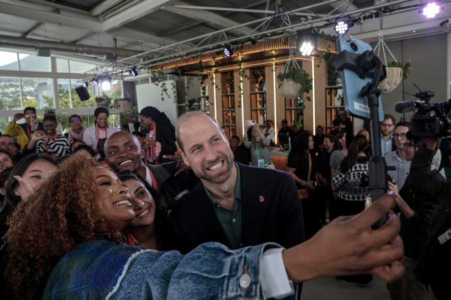 Nomzamo Mbatha, left, the host of Earthshot Week, takes a selfie with Britain's Prince William and a group of young people at the Earthshot Prize Climate Leaders Youth Programme at Rooftop on Bree in Cape Town, South Africa, Monday Nov. 4, 2024. (Gianluigi Guercia/Pool Photo via AP)