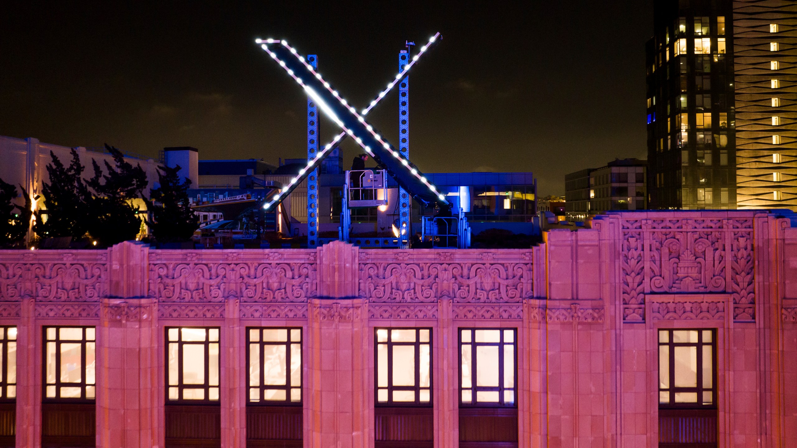 FILE - Workers install lighting on an "X" sign atop the company headquarters, formerly known as Twitter, in downtown San Francisco, July 28, 2023. (AP Photo/Noah Berger, File)