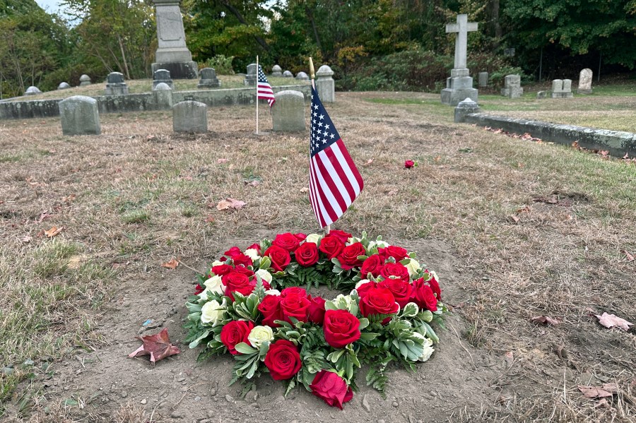 Flowers rest Thursday, Oct. 17, 2024 on the grave of Byron R. Johnson, a Union soldier who was born in Pawtucket, R.I., in 1844 and fought in the Civil War, at Oak Grove Cemetery, in Pawtucket, following Wednesday, Oct. 16, 2024 funeral services for Johnson after his cremated remains were transferred from storage at a cemetery in Seattle. (AP Photo/Michael Casey)