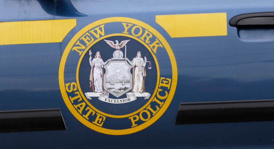 FILE - A New York State Police logo is shown on a state police officer's car near Dannemora, N.Y., Friday, June 12, 2015. (AP Photo/Seth Wenig, File)