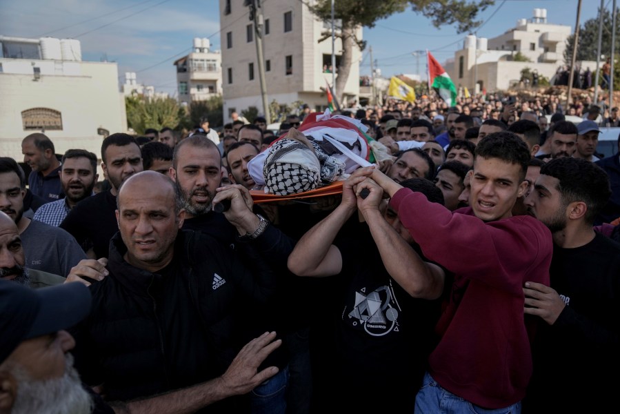 Mourners carry the body of Naji al-Baba,16, who the Palestinian Health Ministry said was killed by Israeli forces in the town of Halhul, West Bank, during his funeral on Monday, Nov. 4, 2024. (AP Photo/Mahmoud Illean)