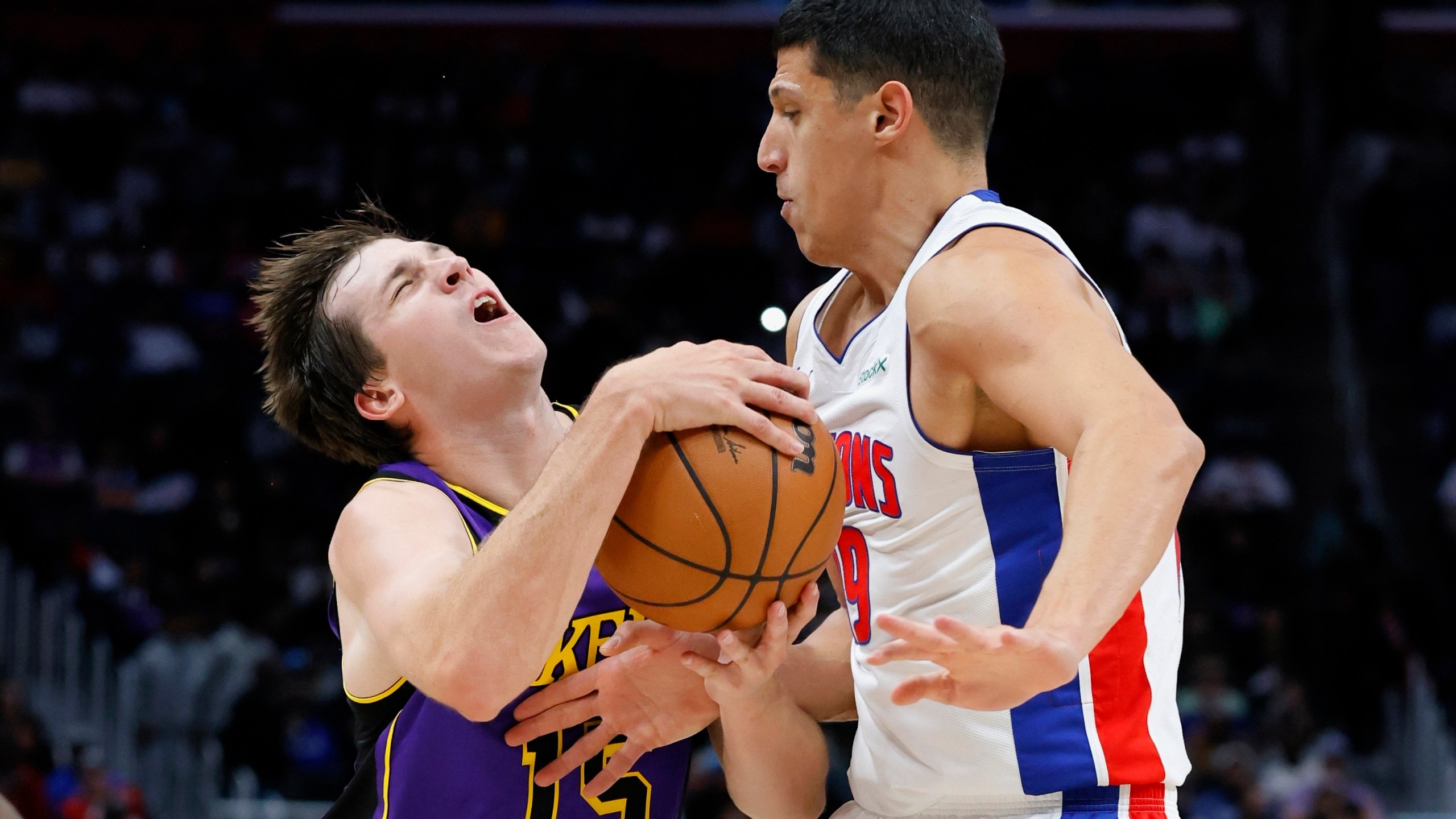 Los Angeles Lakers guard Austin Reaves (15) collides with Detroit Pistons forward Simone Fontecchio (19) while driving to the basket during the first half of an NBA basketball game Monday, Nov. 4, 2024, in Detroit. (AP Photo/Duane Burleson)