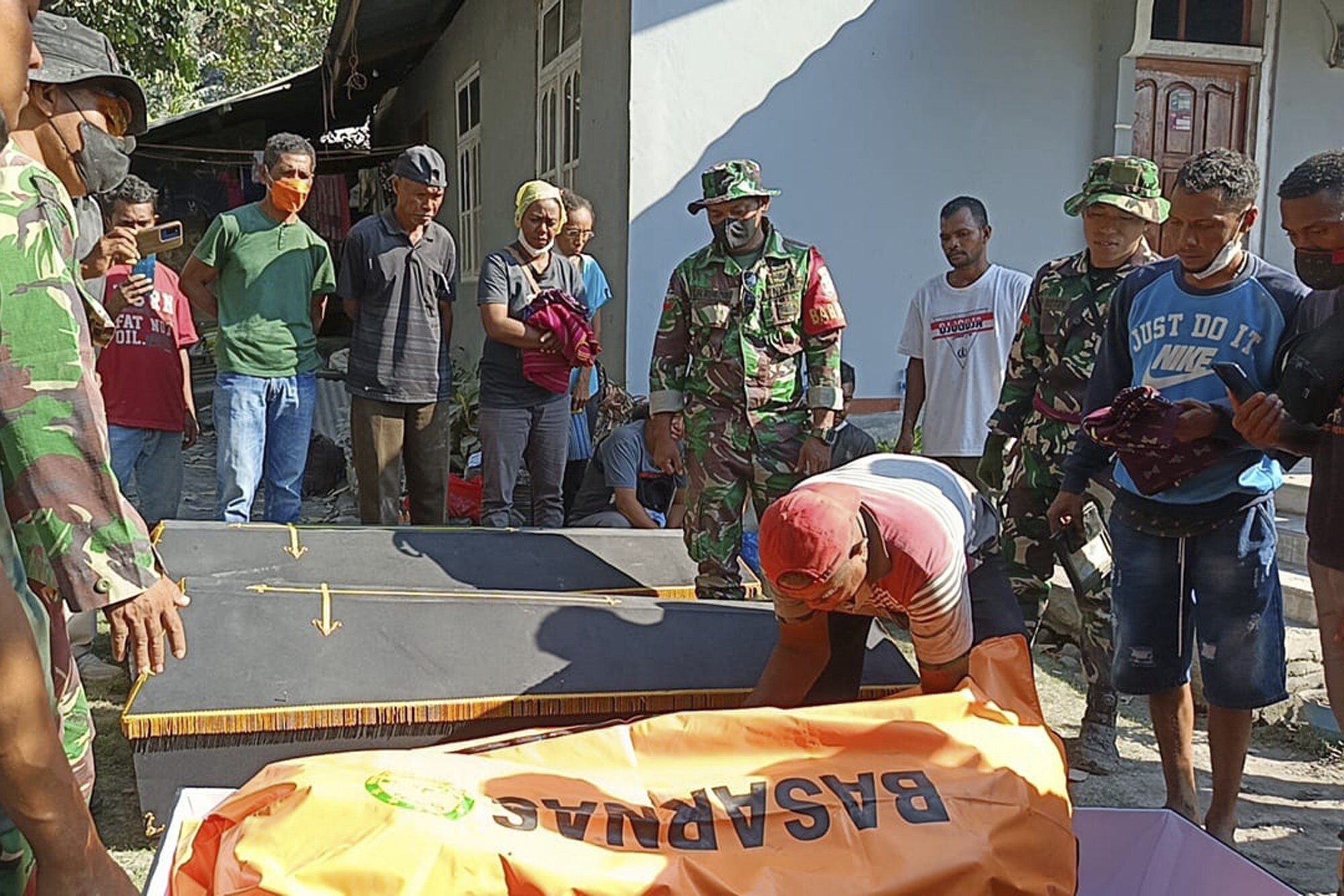 Indonesian soldiers and residents put the body of a victim into a coffin for burial following the eruption of Mount Lewotobi Laki-Laki in East Flores, Indonesia, Monday, Nov. 4, 2024. (AP Photo)