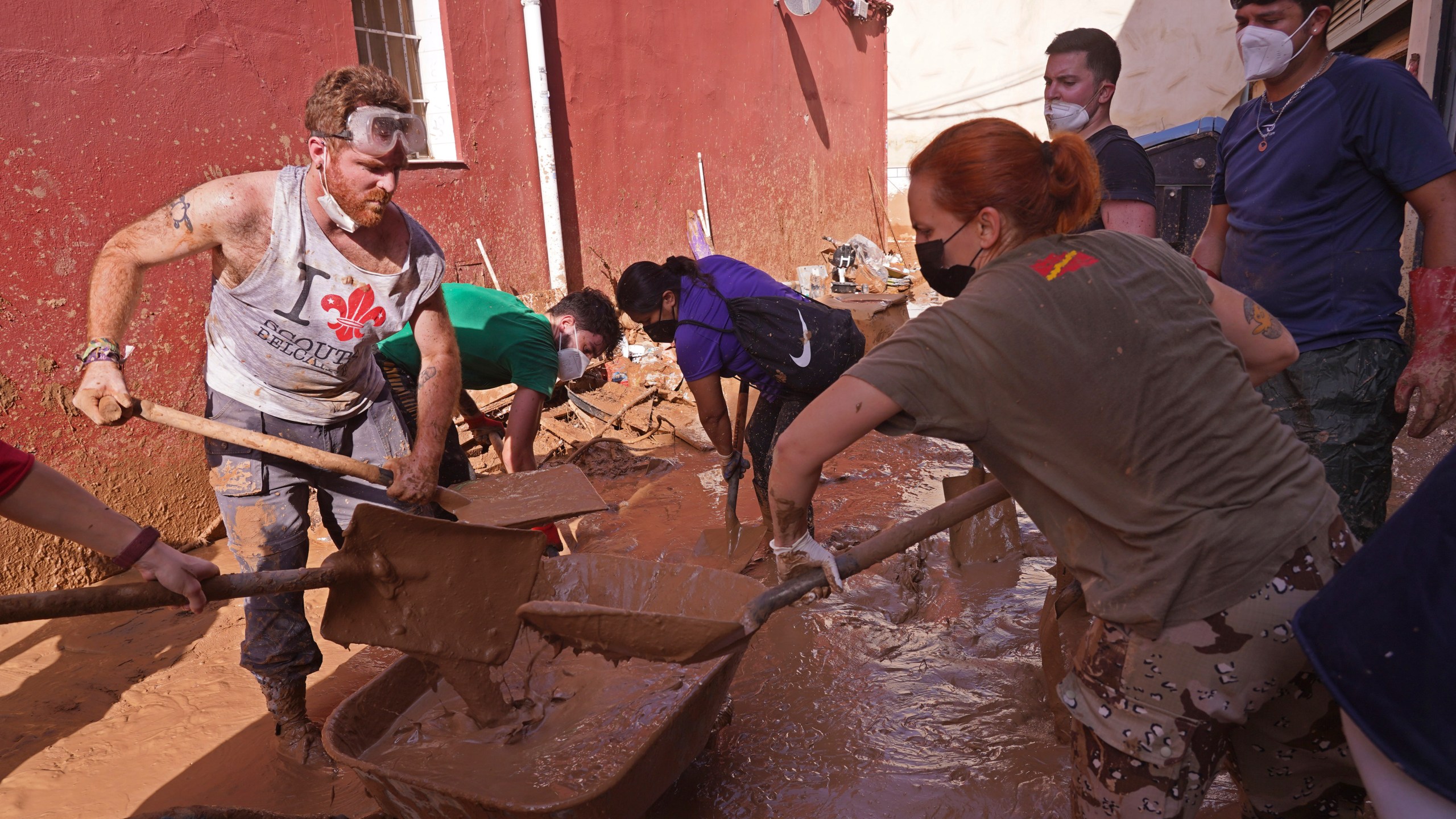 People shovel up mud after floods in Catarroja on the outskirts of Valencia, Spain, Tuesday, Nov. 5, 2024. (AP Photo/Alberto Saiz)