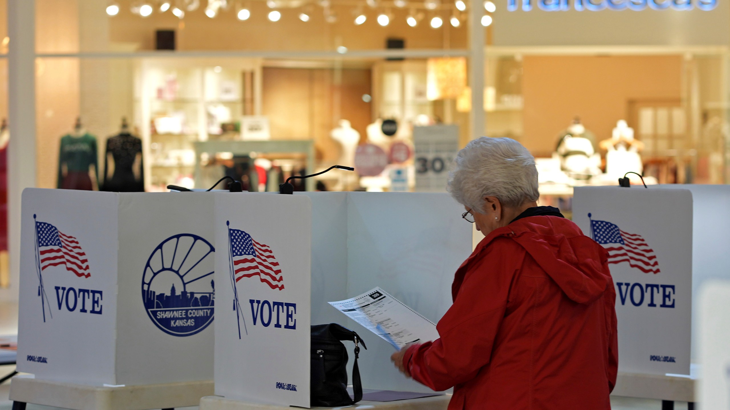 Delores Engel looks over her ballot while voting at the West Ridge Mall Tuesday, Nov. 5, 2024, in Topeka, Kan. (AP Photo/Charlie Riedel)