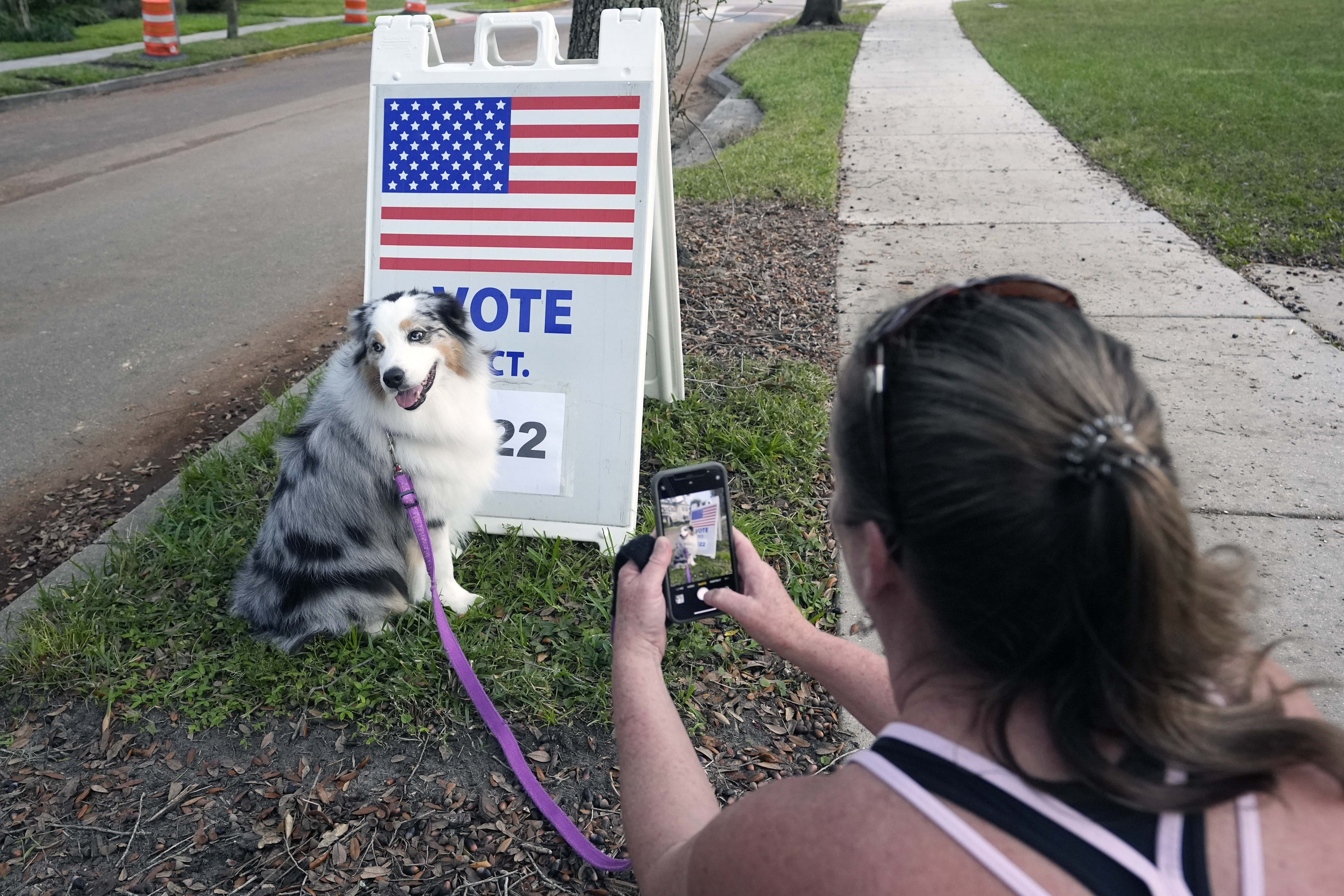 Susan Finan makes photos of her dog Daisey, while waiting for her daughter to cast her ballot at Glenridge Middle School, Tuesday, Nov. 5, 2024, in Orlando, Fla. (AP Photo/John Raoux)