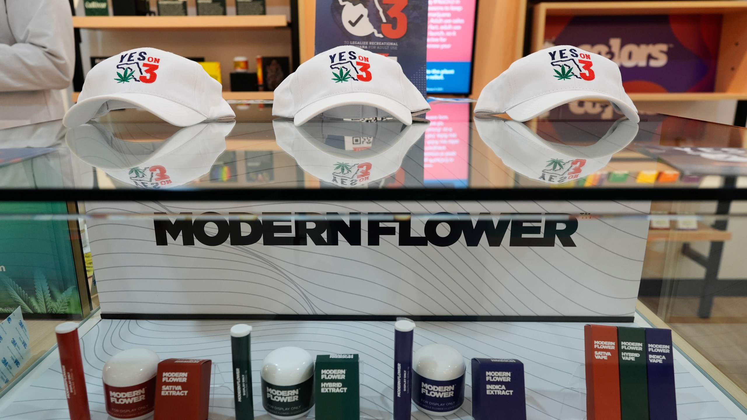 Hats reading "Yes on 3" are displayed amid medical cannabis products at a Trulieve dispensary during an event in support of Amendment 3, a ballot initiative which would legalize the recreational use of pot in Florida for adults 21 years old and older, Wednesday, Oct. 23, 2024, in Hallendale Beach, Fla. (AP Photo/Rebecca Blackwell)