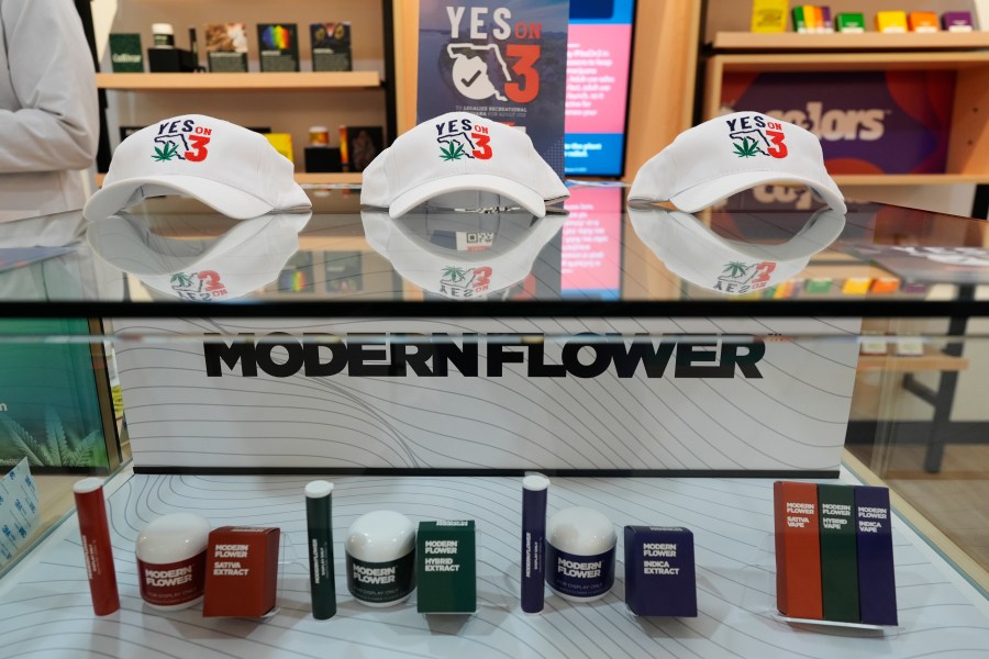 Hats reading "Yes on 3" are displayed amid medical cannabis products at a Trulieve dispensary during an event in support of Amendment 3, a ballot initiative which would legalize the recreational use of pot in Florida for adults 21 years old and older, Wednesday, Oct. 23, 2024, in Hallendale Beach, Fla. (AP Photo/Rebecca Blackwell)