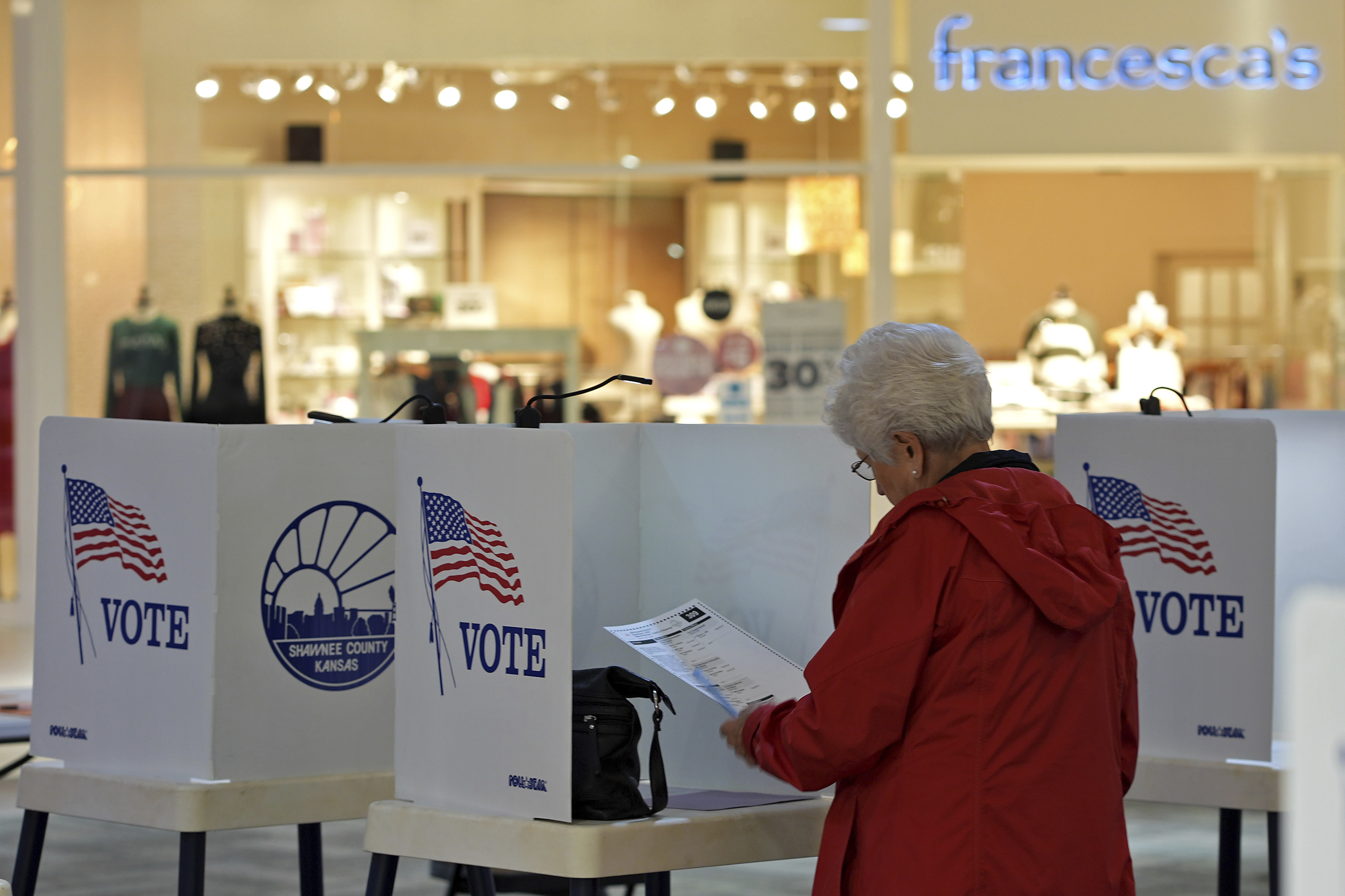 Delores Engel looks over her ballot while voting at the West Ridge Mall Tuesday, Nov. 5, 2024, in Topeka, Kan. (AP Photo/Charlie Riedel)