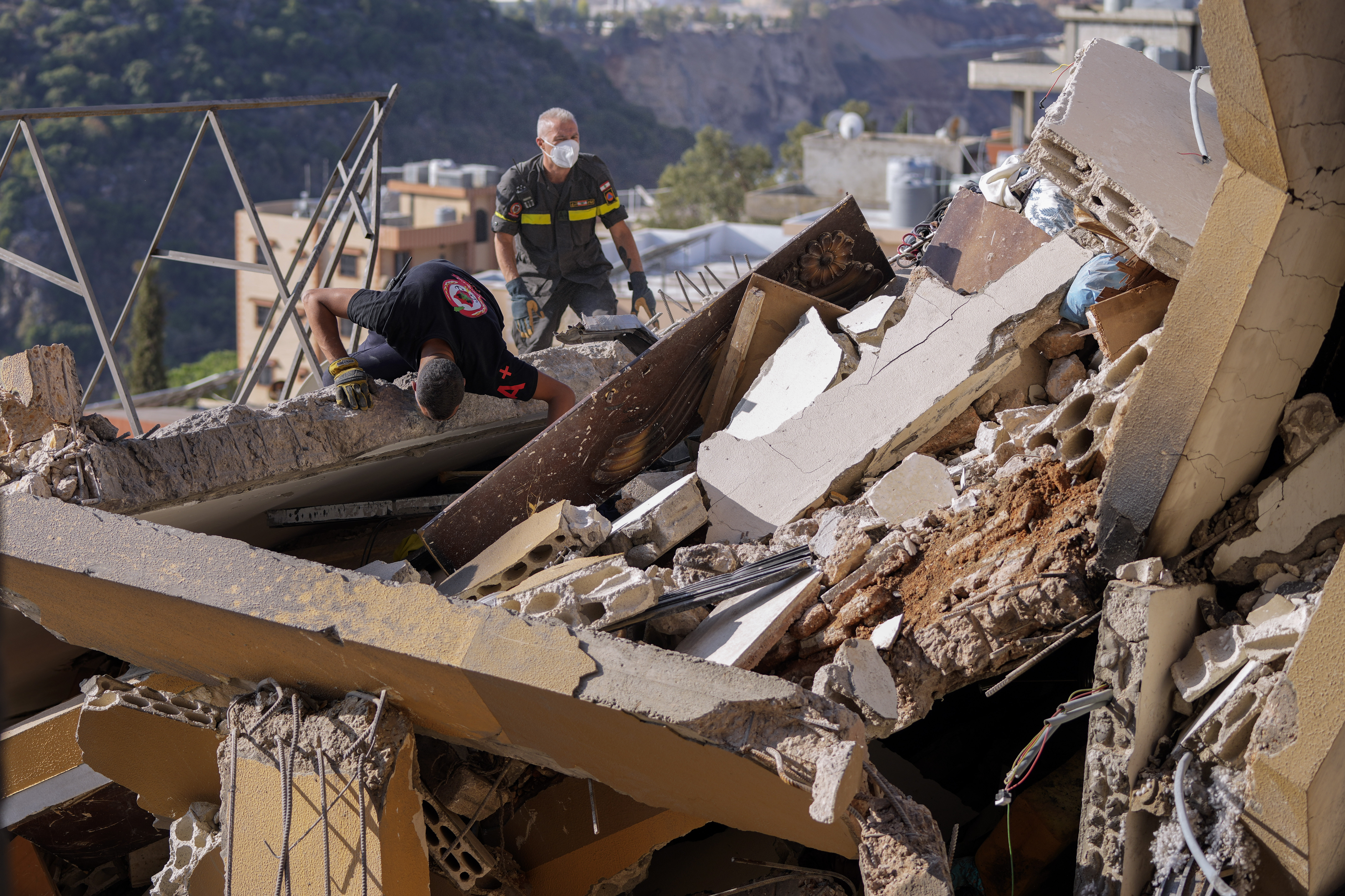 Rescue workers search for victims in the rubble of a destroyed building hit in an Israeli airstrike on Tuesday night, in Barja, Lebanon, Wednesday, Nov. 6, 2024. (AP Photo/Hassan Ammar)