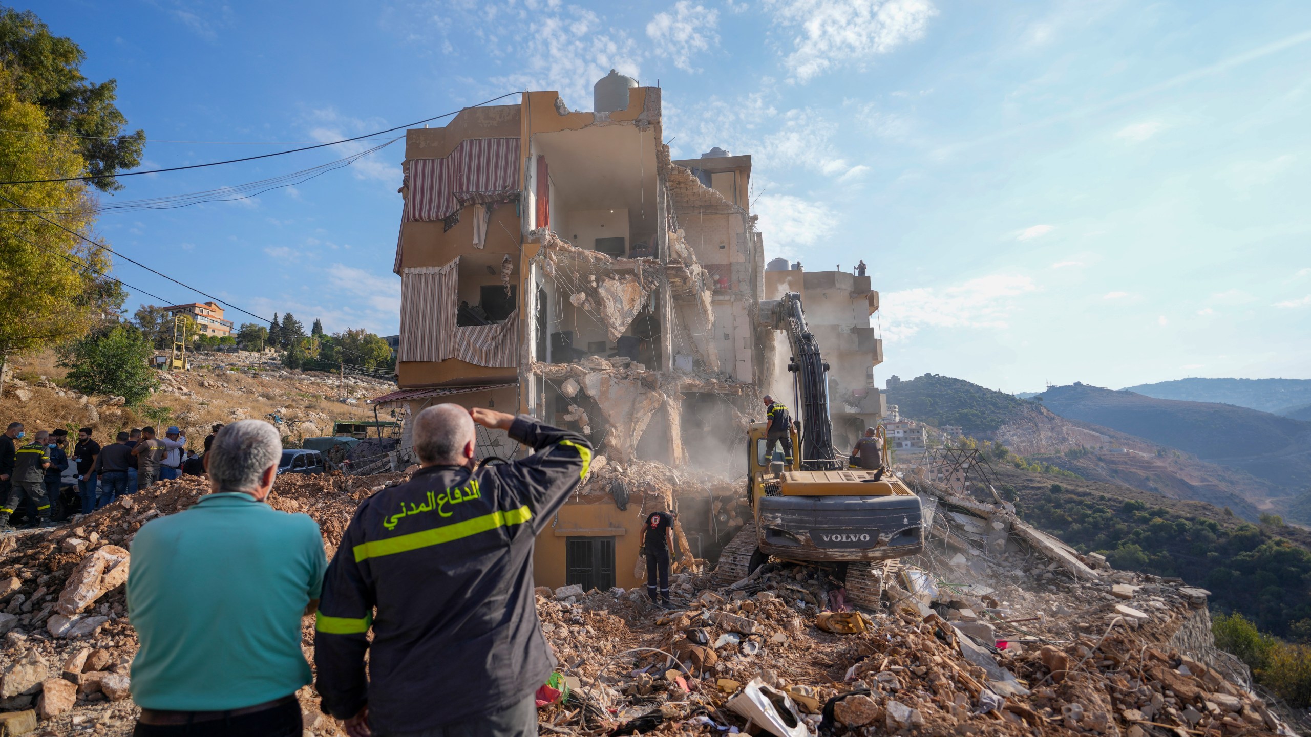 Rescue workers use excavators to remove the rubble of a destroyed building that was hit Tuesday night in an Israeli airstrike, as they search for victims in Barja, Lebanon, Wednesday, Nov. 6, 2024. (AP Photo/Hassan Ammar)