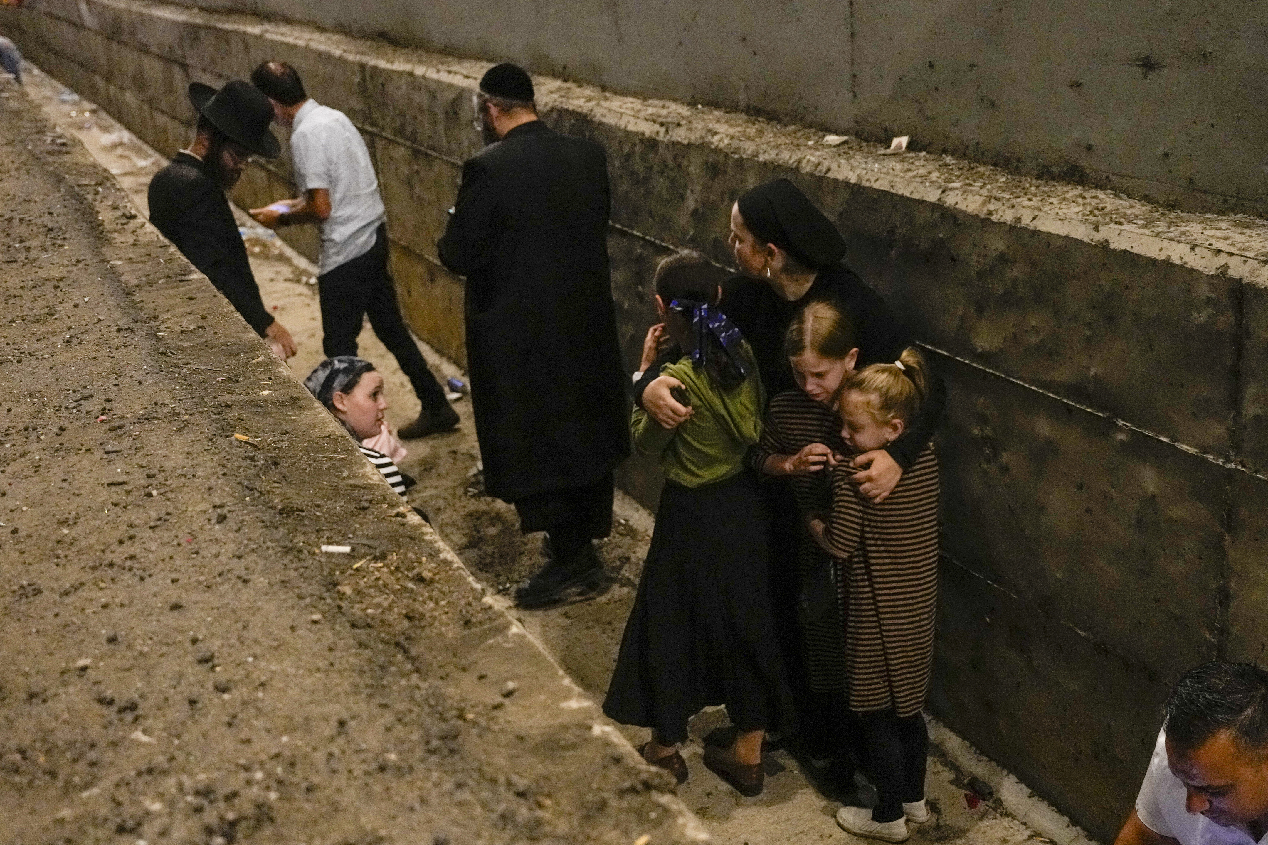 FILE - People take cover on the side of the road as a siren sounds a warning of incoming missiles fired from Iran on a freeway in Shoresh, between Jerusalem and Tel Aviv in Israel Tuesday, Oct. 1, 2024.(AP Photo/Ohad Zwigenberg, File)