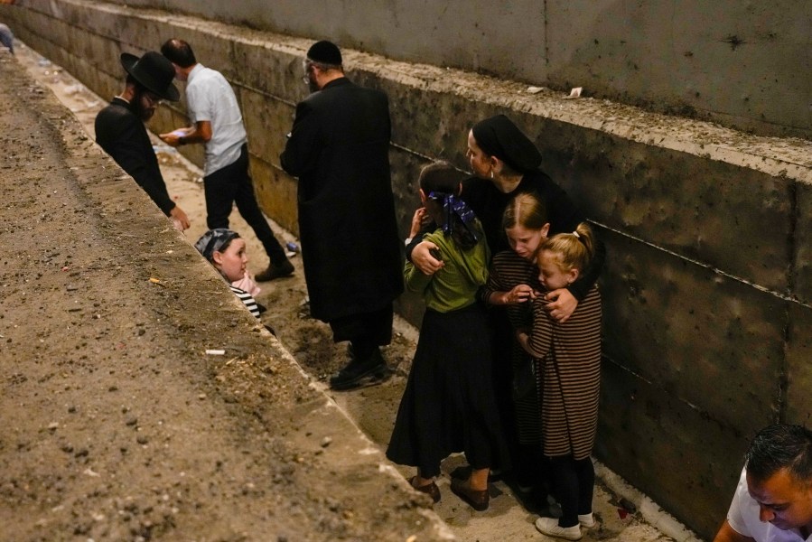 FILE - People take cover on the side of the road as a siren sounds a warning of incoming missiles fired from Iran on a freeway in Shoresh, between Jerusalem and Tel Aviv in Israel Tuesday, Oct. 1, 2024.(AP Photo/Ohad Zwigenberg, File)