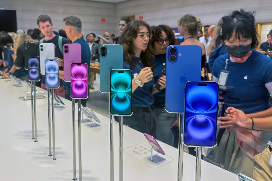 FILE - People gather near a display of iPhone 16's at the Apple Store on 5th Ave. in New York on September 20, 2024.(AP Photo/Ted Shaffrey, File)