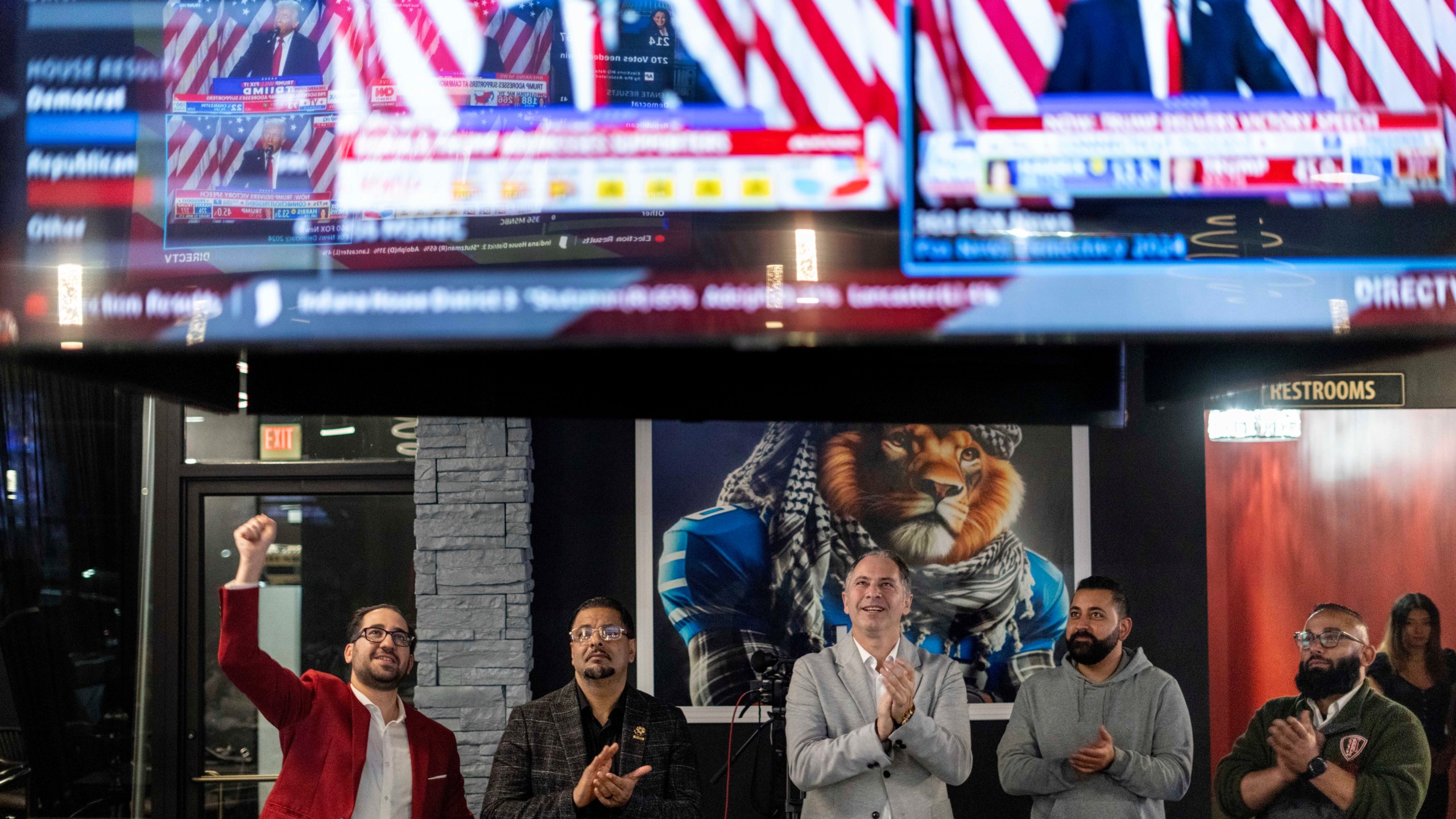 From left to right, Paul Manni, Sam Alasri, Wasel Yousaf, Waseem Makani and Abrahim Tamimi, cheer as former President Donald Trump's speech is broadcast during an Arab Americans for Trump watch party at the Lava Java Cafe, a hookah lounge, in the early hours of Wednesday, Nov. 6, 2024, in Dearborn, Mich. (AP Photo/David Goldman)