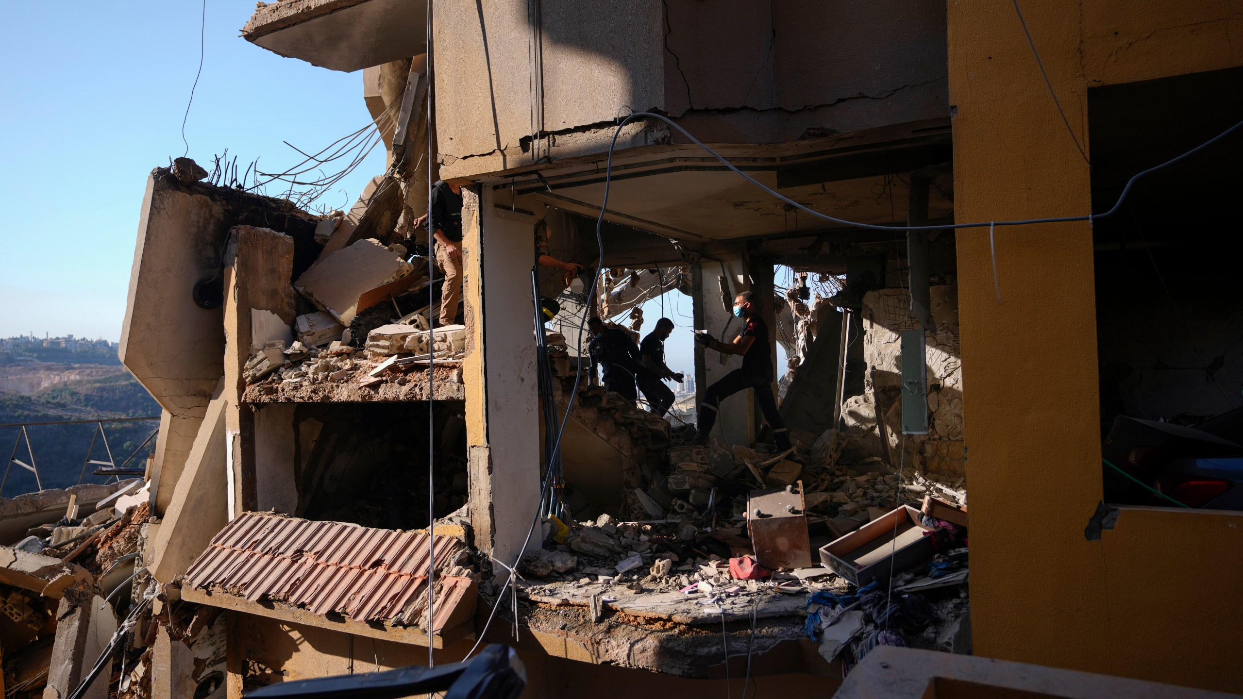 Rescue workers search for victims in the rubble of a destroyed building hit in an Israeli airstrike on Tuesday night, in Barja, Lebanon, Wednesday, Nov. 6, 2024. (AP Photo/Hassan Ammar)